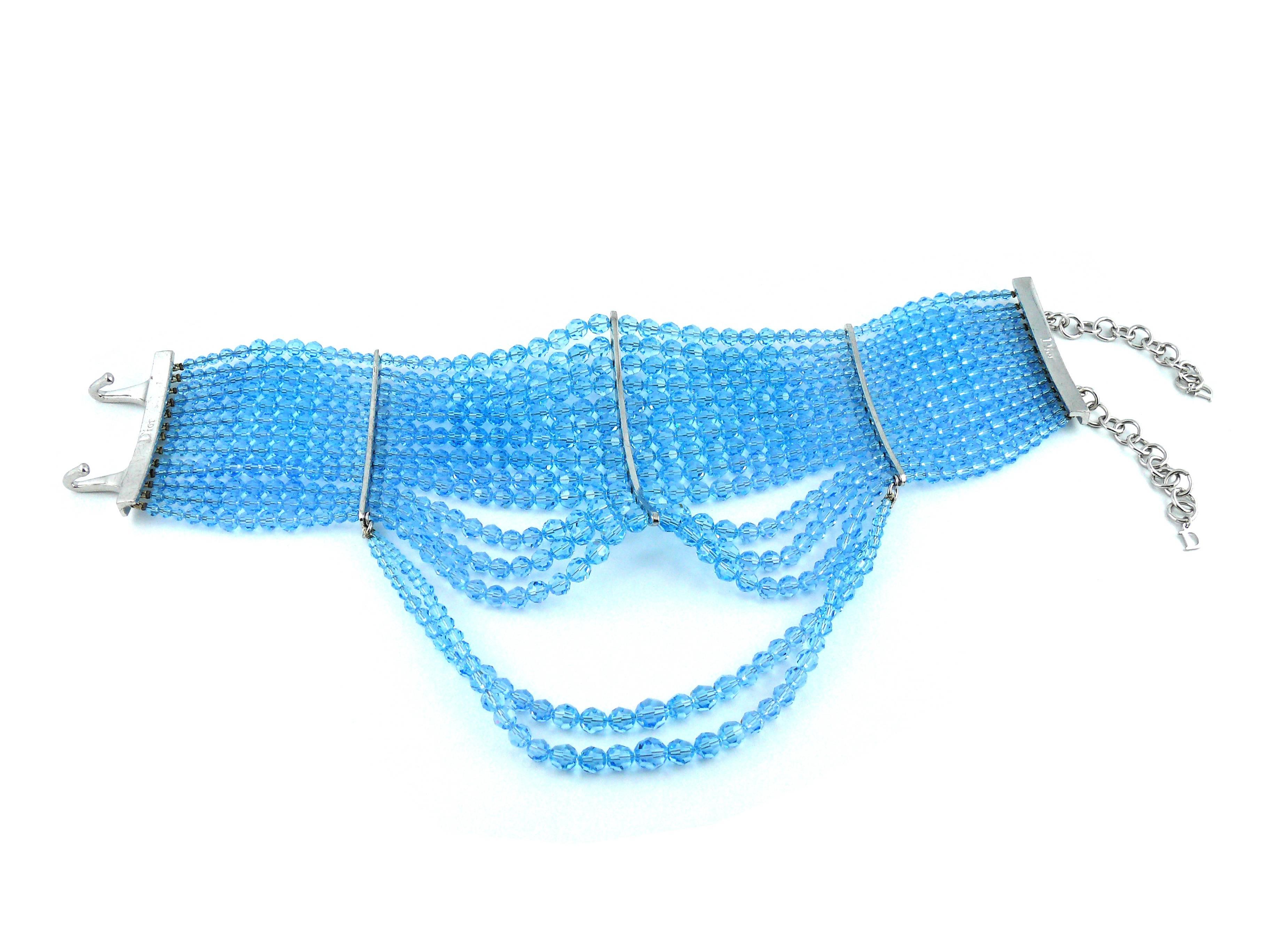 Le collier ras du cou CHRISTIAN DIOR by John Galliano de la collection Masai Couture est composé de 15 rangs de perles à facettes en cristal Swarovski bleu aqua. 

Métal de couleur argentée. 
Fermeture par crochet et anneau. 

Marqué Dior. 

Mesures