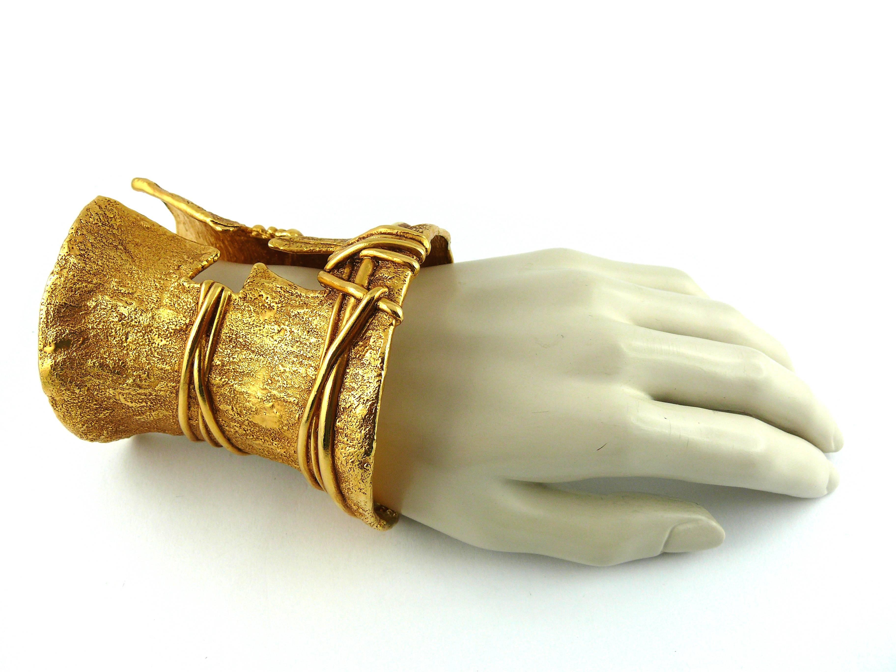 CHRISTIAN LACROIX massive vintage gold tone textured cut out cross cuff bracelet.

Antique patina finish.

A truly stunning statement piece !

Marked Christian Lacroix CL Made in France.

Note
As a buyer, you are fully responsible for