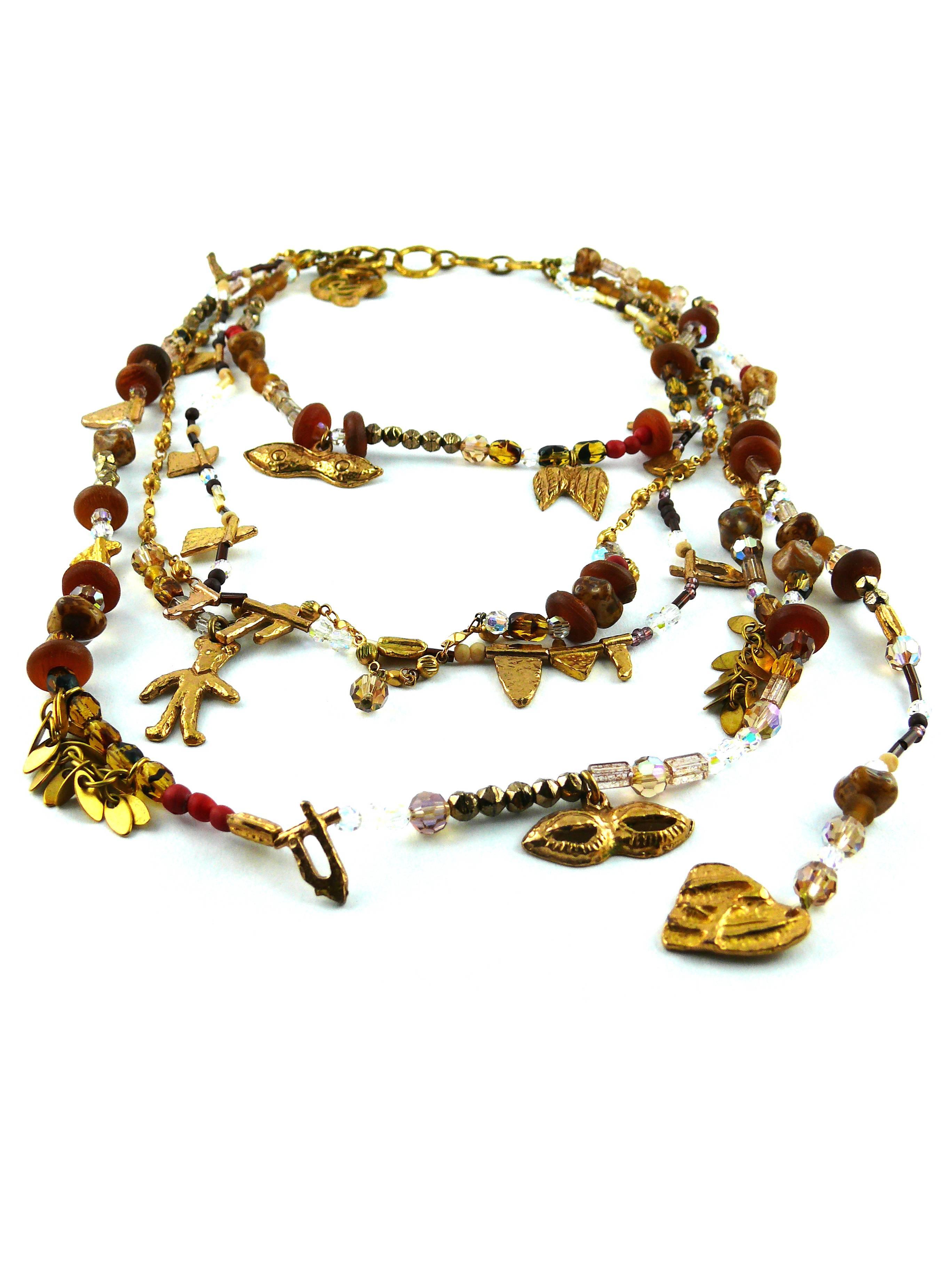 CHRISTIAN LACROIX vintage multi strand voodoo style necklace.

Beaded chains embellished with gold tone abstract forms and charms (masks, figure, heart, wings).

Marked Christian Lacroix CL Made in France.

Comes with its original