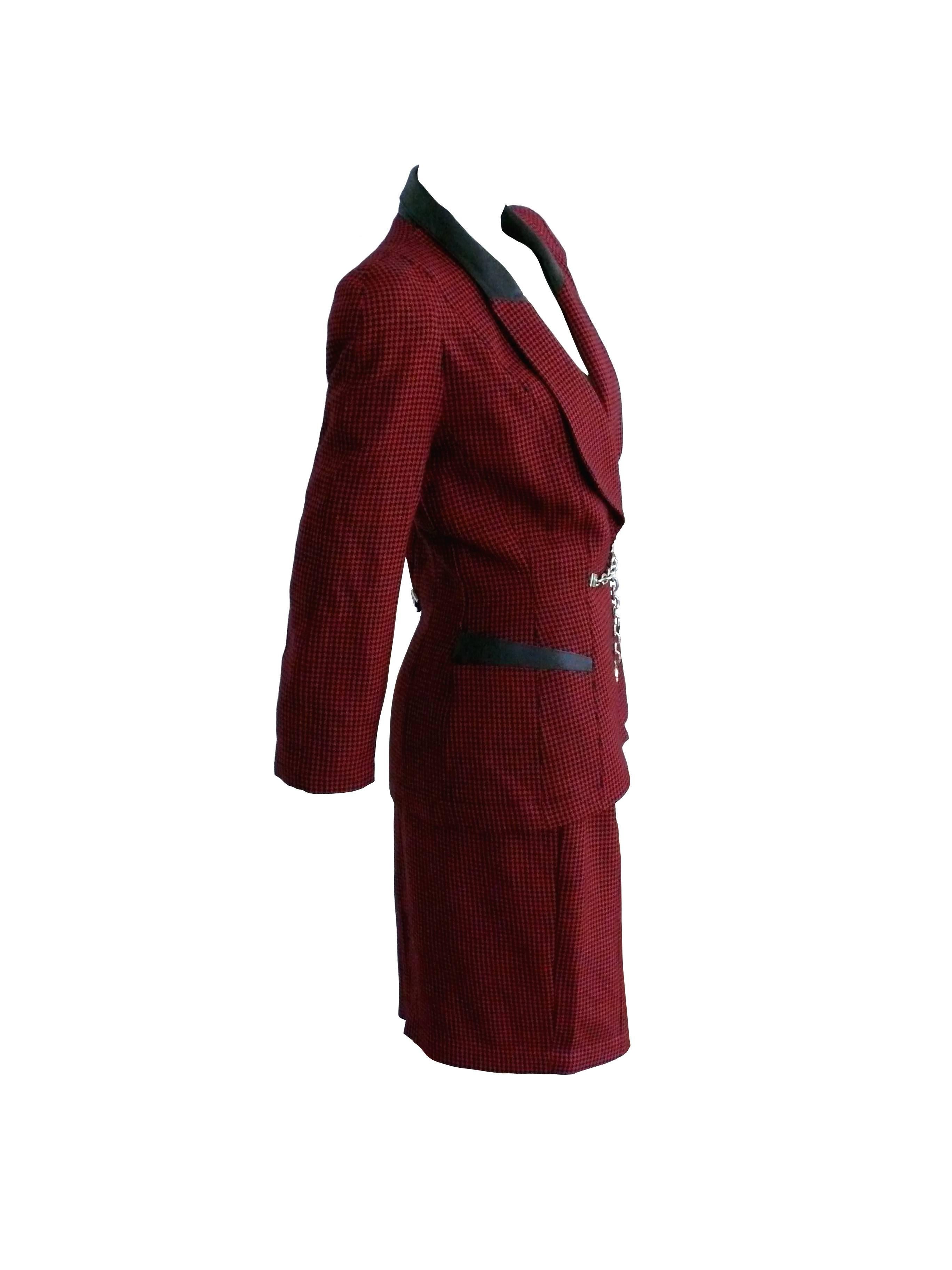 THIERRY MUGLER vintage classic 1940s inspired red-black houndstooth wool skirt suit with leather and chain details.

Jacket has shoulder pads and black leather detail on top of the lapels. 
Two pockets.
Hidden snap closure.
Massive silver tone