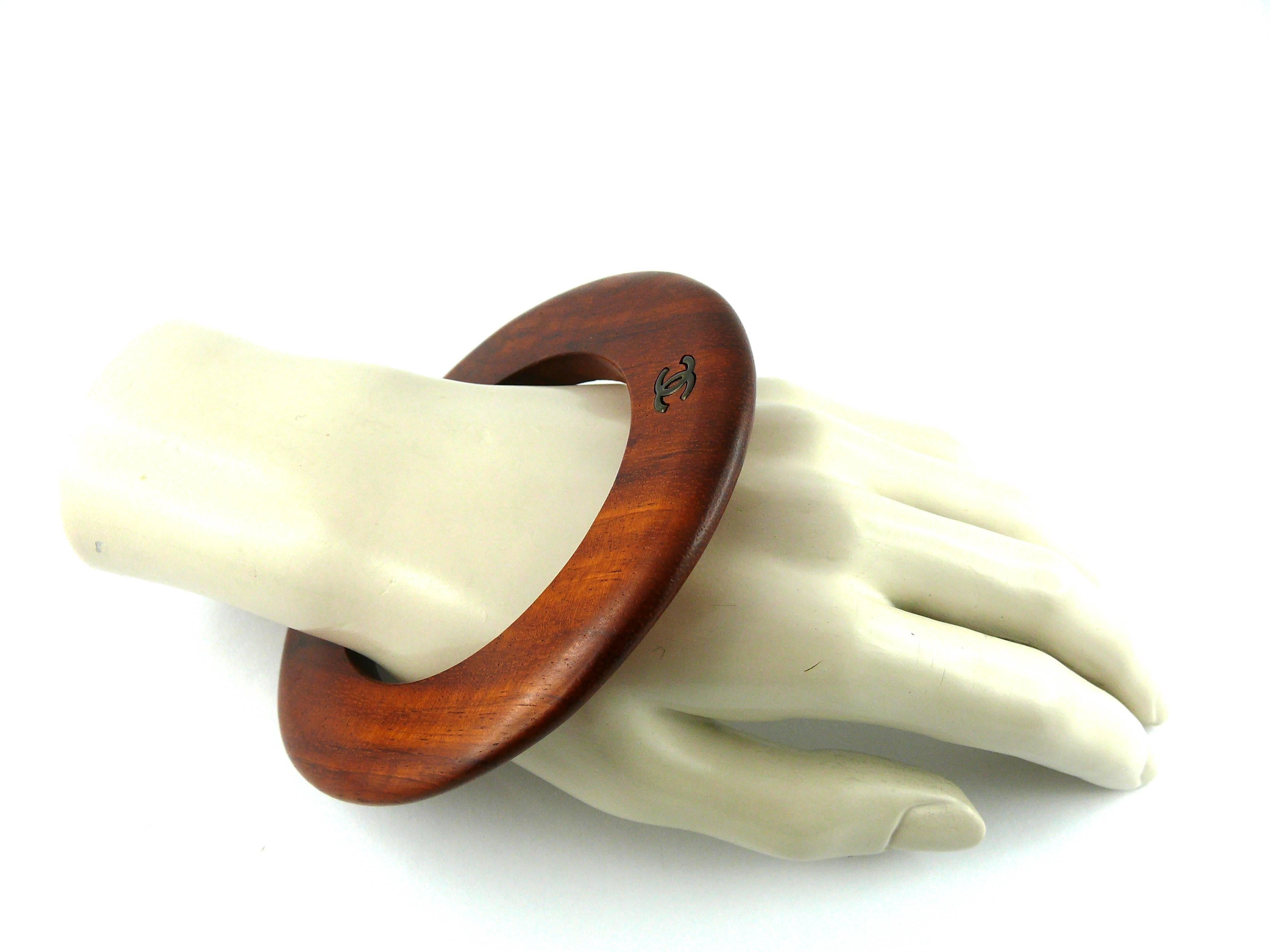 CHANEL vintage exotic wood bangle bracelet featuring a bronze patina double C logo.

Fall 1996 Collection.

This bangle has an elegant modern shape and a very soft and smooth texture from the oustide. 
Looks great with many outfits, for wearing