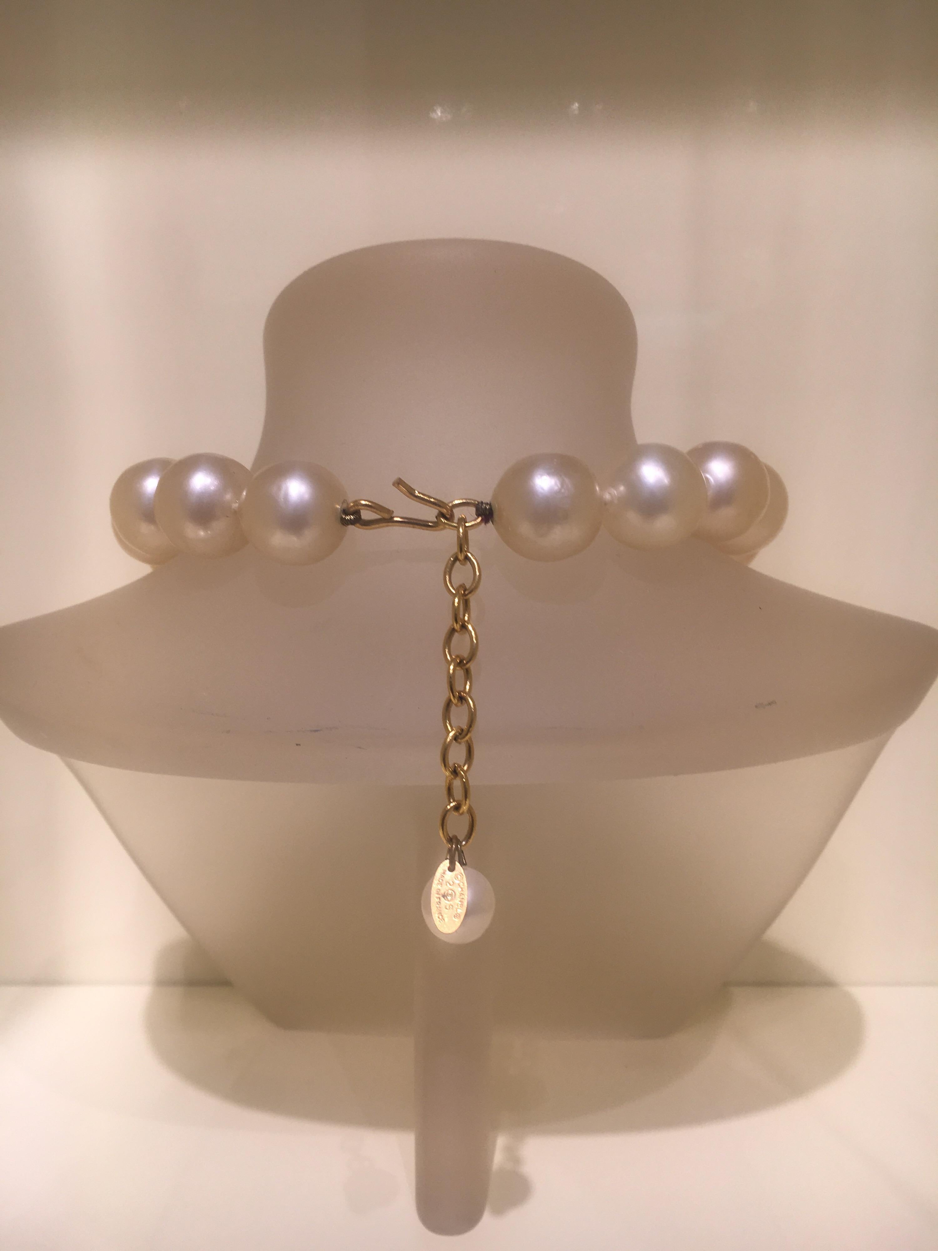 Ivory faux pearl Chanel bead strand necklace with a knotted cord. The necklace closes at the back with a gold chain and hook closure.  A gold Chanel tag with engraved signature CC at the back and marked collection 25. In excellent condition, a