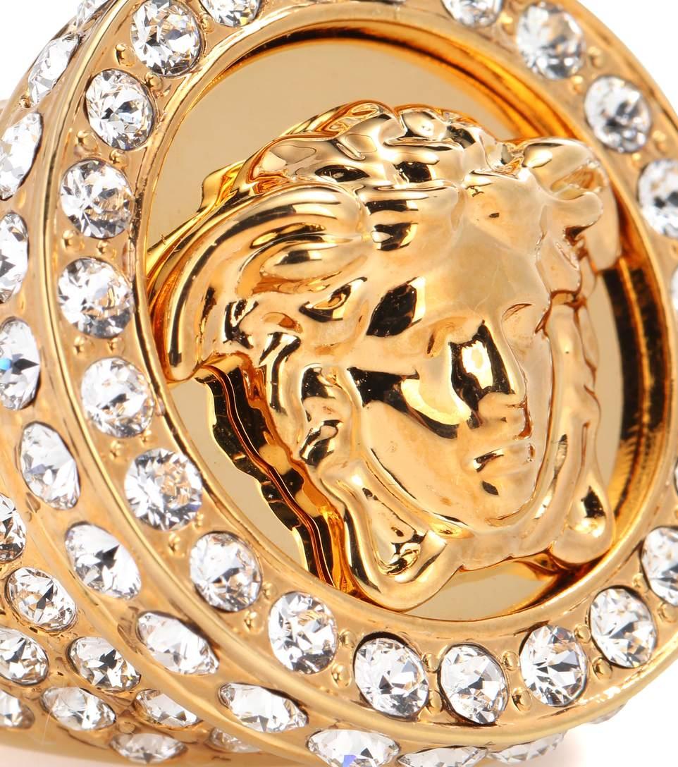 VERSACE
Gold Medusa Crystal Embellished Ring

Experience the height of dramatic elegance. Crystal adorned beauty creates a stunning showstopper. 

Indulge in luxurious glamour with Versace’s All Over Bling Ring. 

Effortlessly enhance your fashion
