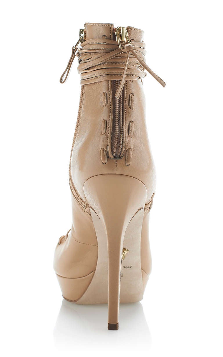 VERSACE NUDE LACE UP SHOES

This pointed-toe, lace-up Versace bootie features exposed stitching detail at the back zip.

Side zip 

Leather insole 

Leather sole 

100% leather 

Made in Italy

Covered heel measures 5.25 inches