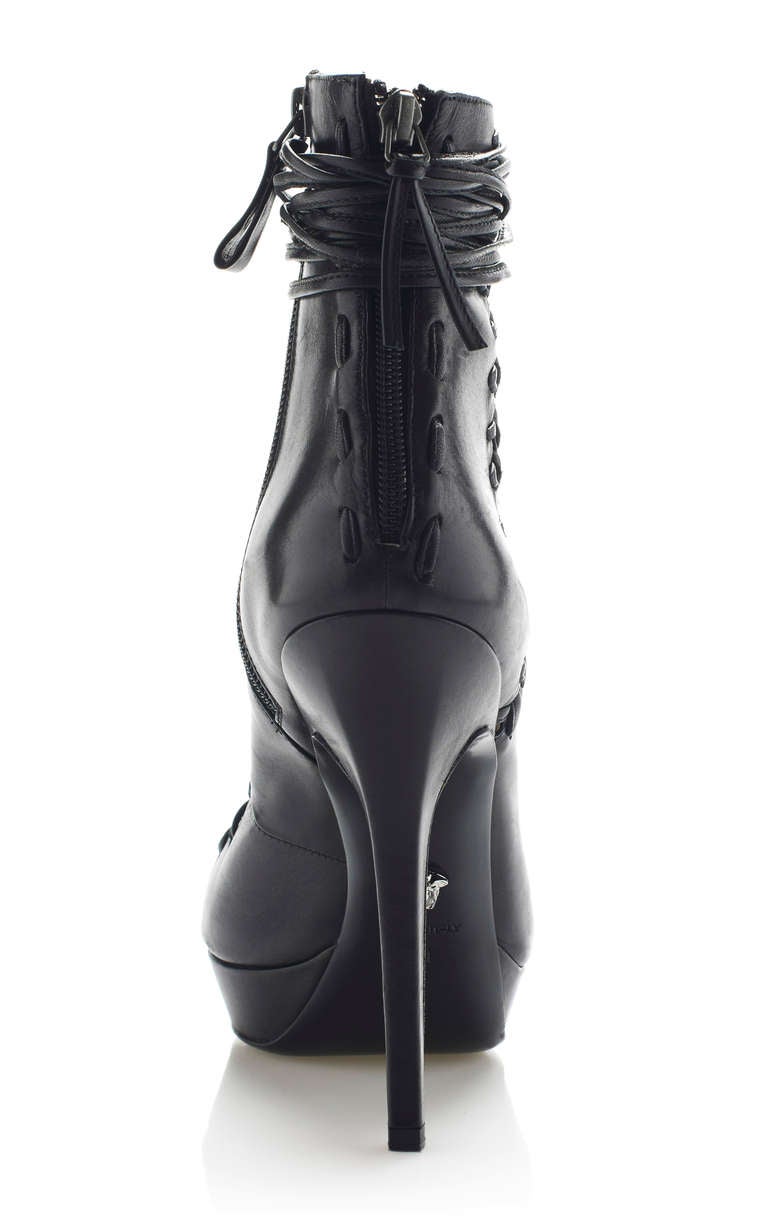 This pointed-toe, lace-up Versace bootie features exposed stitching detail at the back zip.

Side zip 

Leather insole 

Leather sole 

100% leather 

Made in Italy

Covered heel measures 5.25 inches 

Platform measures 1 inch

Size:  38

Made in