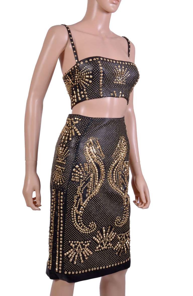 NEW VERSACE  SKIRT AND BRA-TOP

The black leather pencil skirt features all-over metal studded detail.

Exposed double back zip 

100% leather

Fully lined 

Made in Italy

The bra top has two straps and also studded. Top features