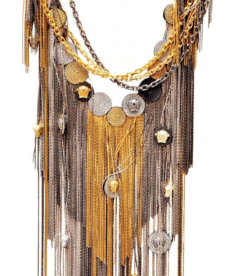 VERSACE

Metallic necklace featuring gold-tone and silver-tone long fringes with circular details on a gold-tone chain with a clip fastening and a small logo coin.

Closes with adjustable chain. 

Composition: 100 % metal

Made in