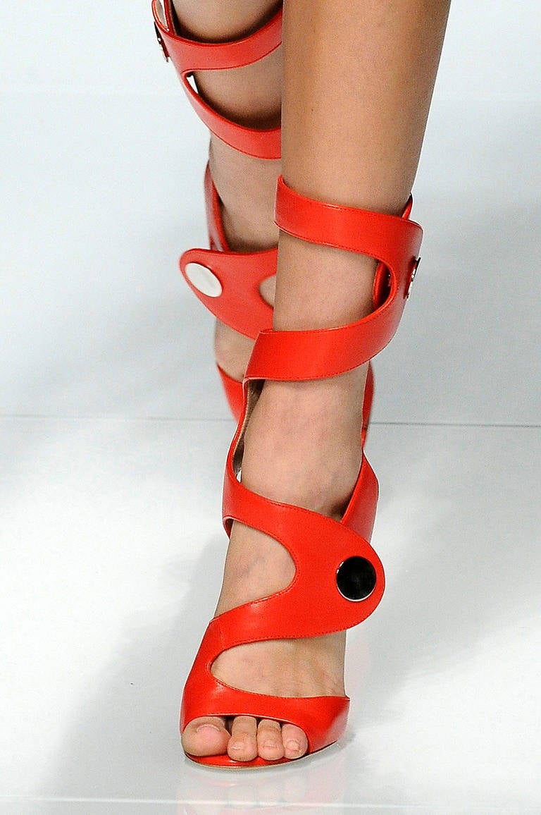 VERSACE SANDALS

Red leather sandals with a heel that measures approximately 115mm/ 4.5 inches. 

Versace sandals have a round toe and silver button details at elasticated press-stud fastening wide cutout straps.

Size is 40 - US 10

Made in