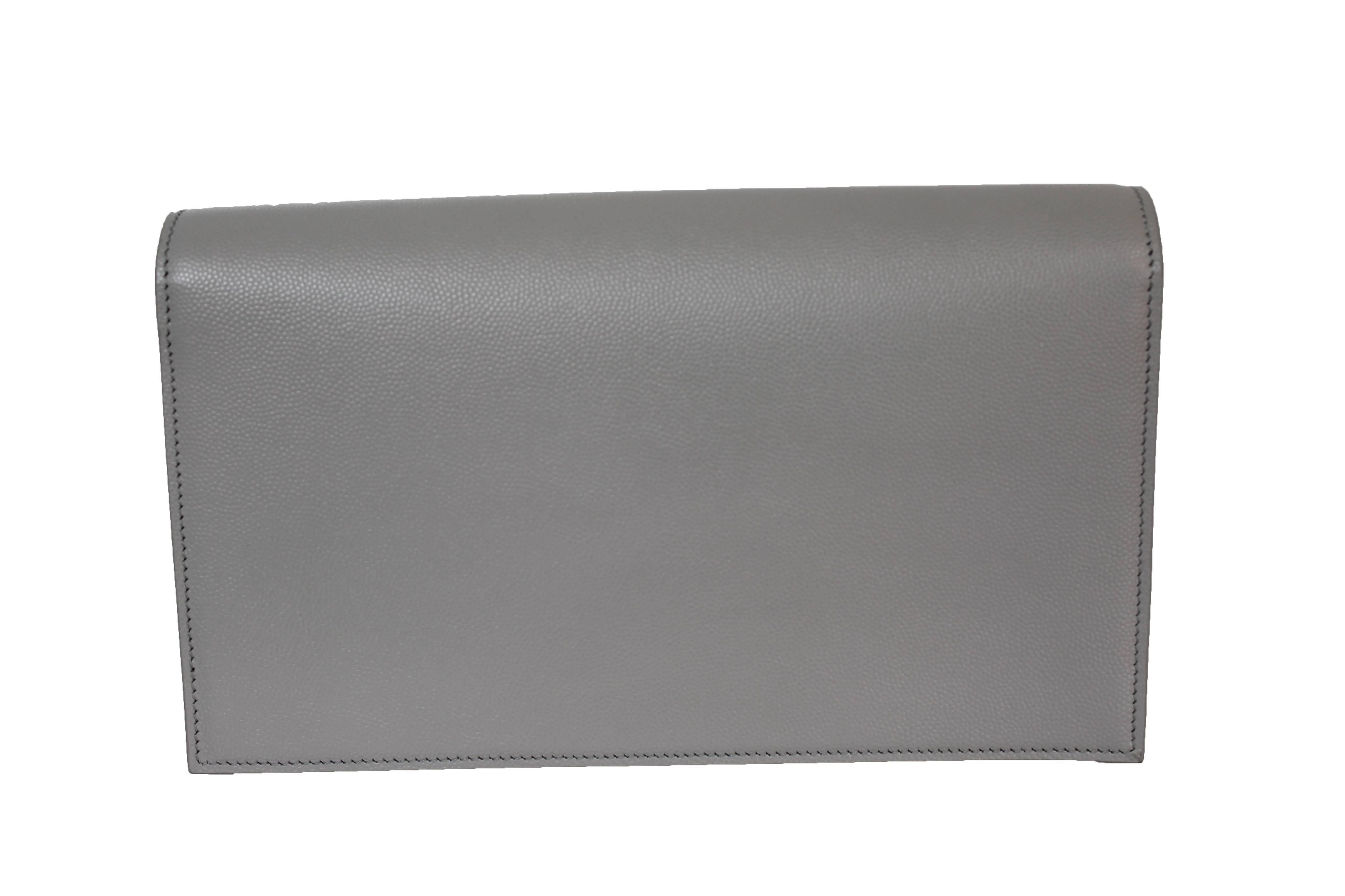 Item is new without tags.

A gleaming silvertone insignia polishes the front of a svelte, grained calfskin clutch that represents the epitome of fashionable elegance.

Magnetic snap-flap closure.
Interior wall pocket.
Leather.
By Saint