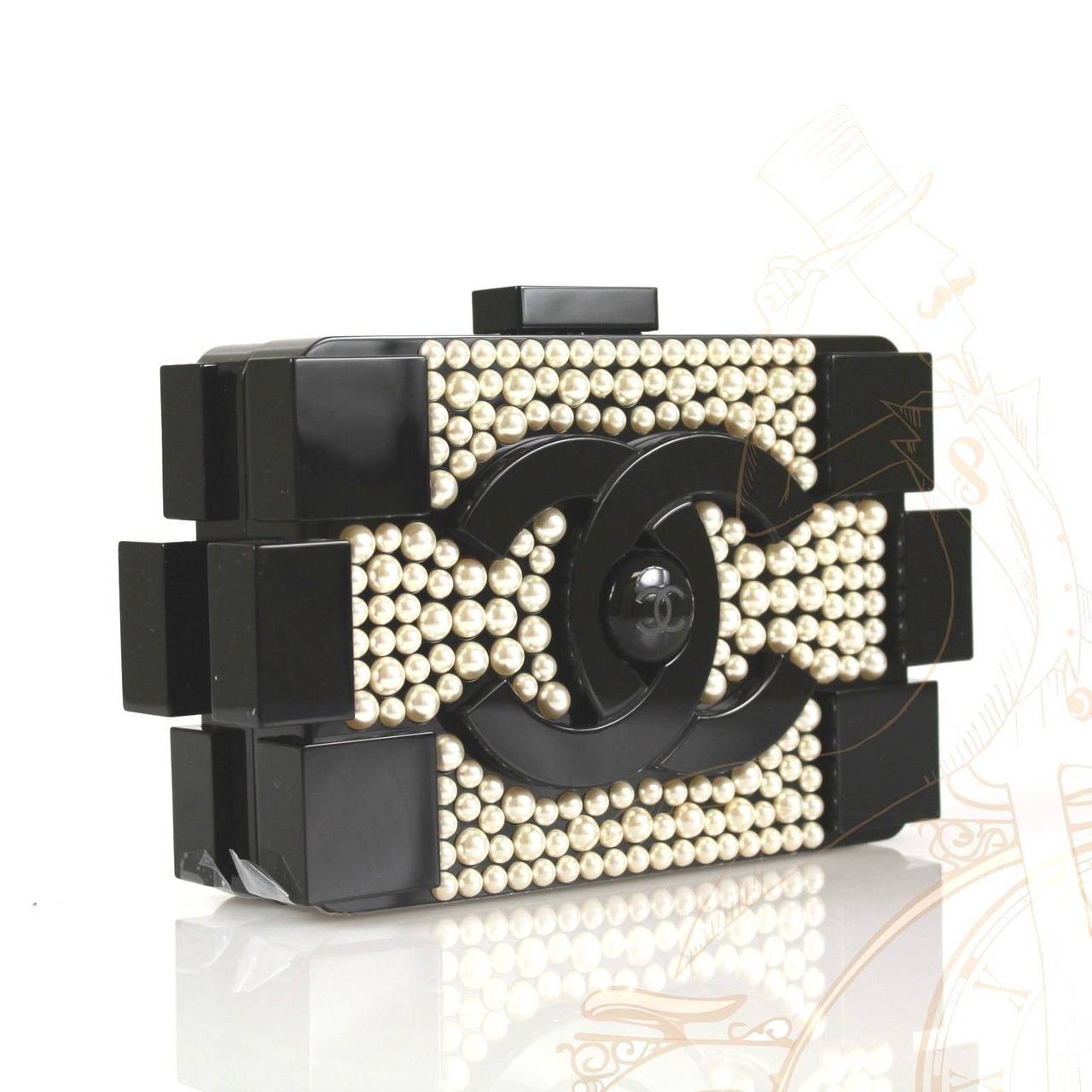 This rare and gorgeous style features faux pearl detail on front and back, large black CC logo with CC center, and faux pearl shoulder/crossbody strap which can be tucked inside and worn as a clutch.

The interior is lined in black leather with
