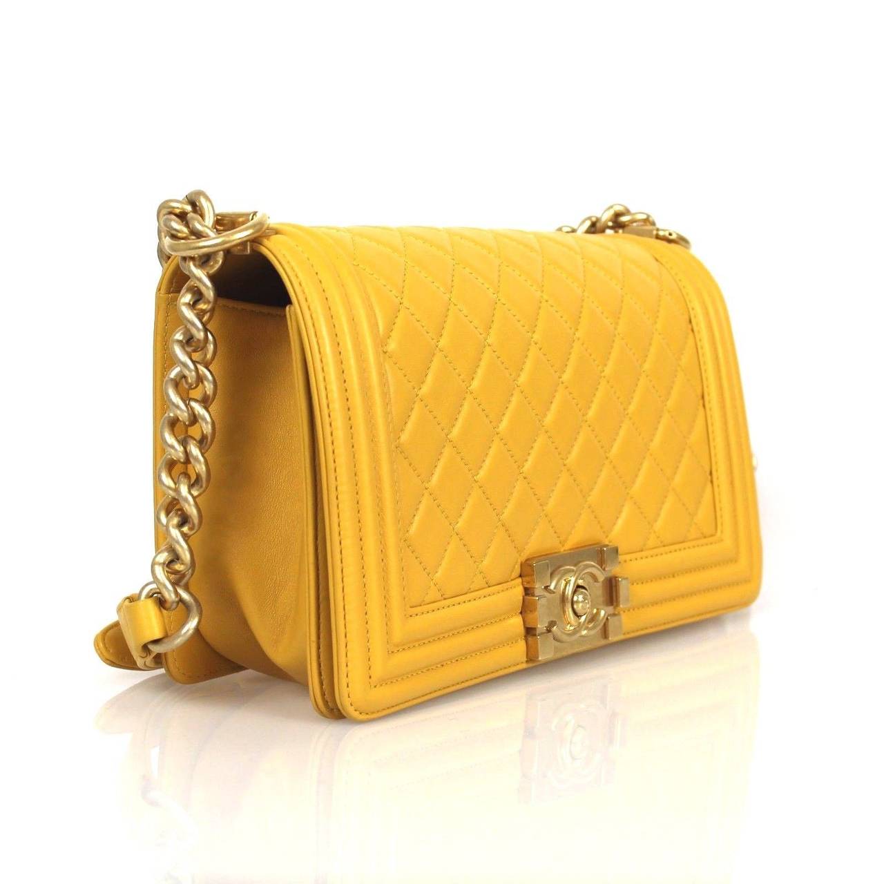 Medium Boy in a exquisite yellow calfskin with gold metal. The bag is of quilted leather trimmed in smooth leather with smooth leather sides and bottom; it has a full front flap with Boy Chanel signature CC push lock closure and gold chain link and