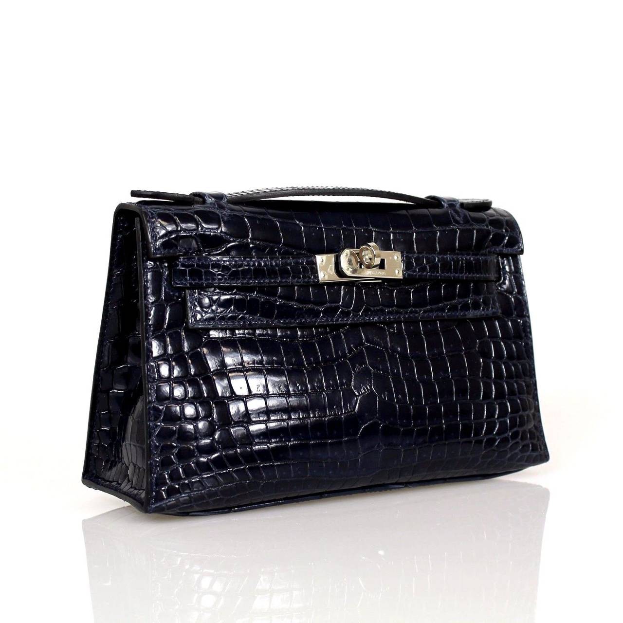 This Pochette features a little top handle. This item in navy Crocodile is  accentuated with palladium hardware. This color is very sophisticated and easy to wear. This easily carried day or night, casual to dressy. 
Stamped HERMES MADE IN PARIS on
