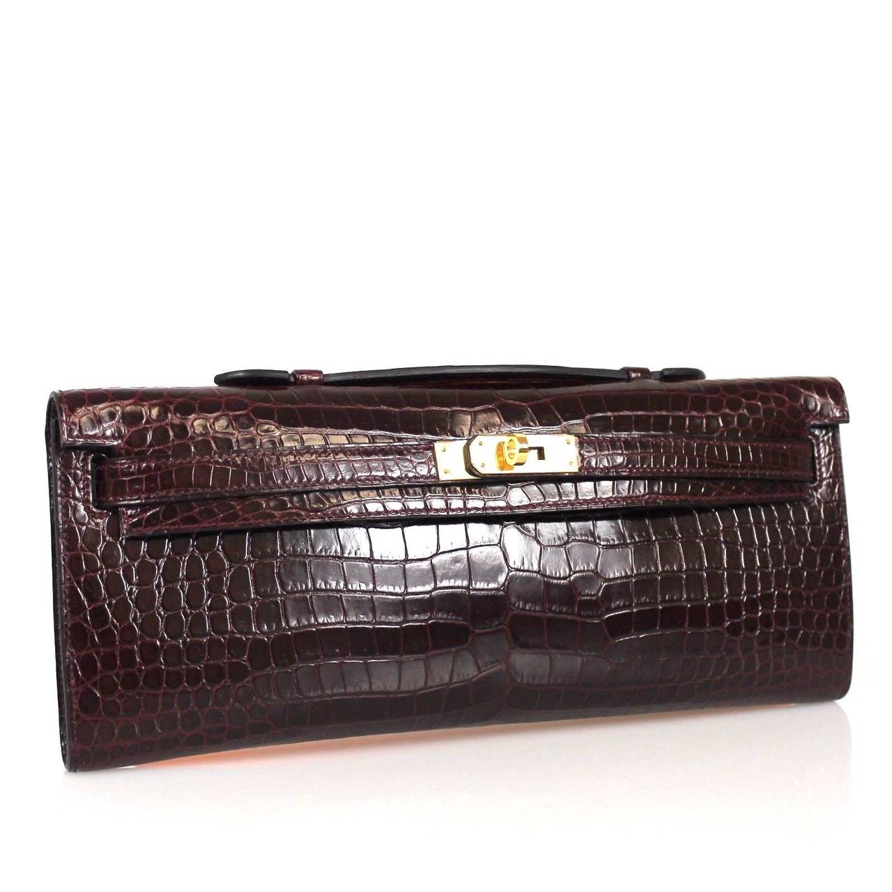 This is an authentic Hermes Niloticus Crocodile Kelly Cut Pochette clutch. This highly coveted clutch is crafted of luxurious Niloticus crocodile. In the style of the Kellys, the clutch has a clutch top handle, a cross over flap and strap closure