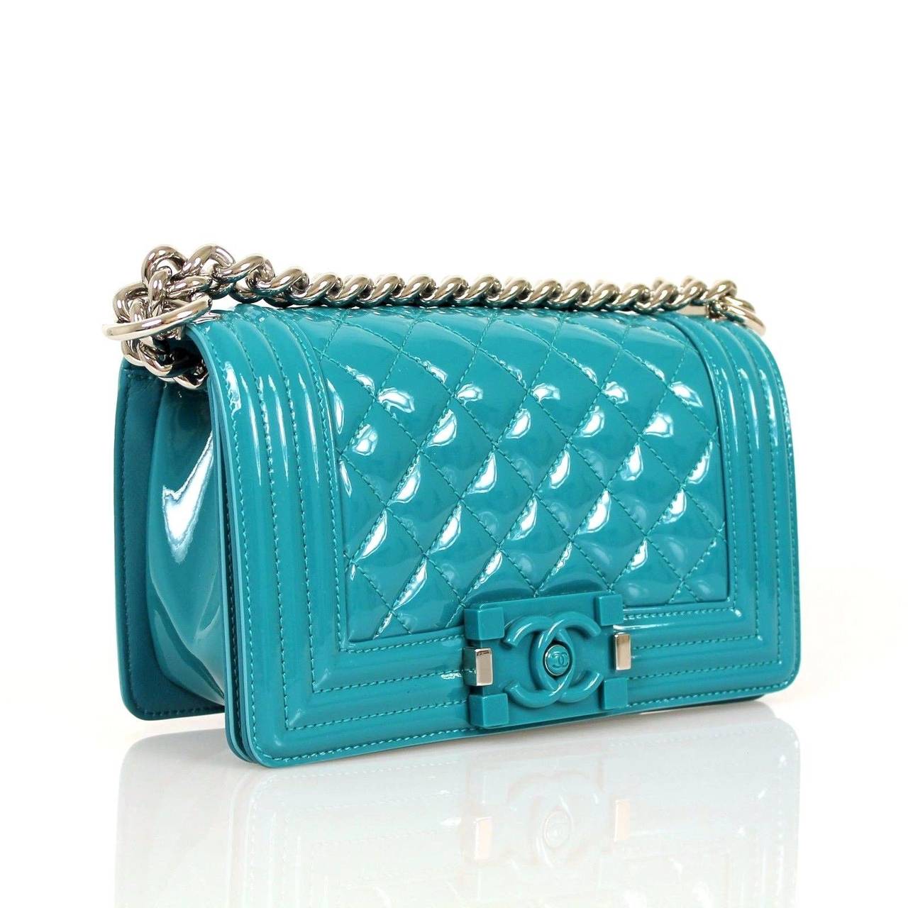 Chanel Patent Boy Bags for the Cruise 2015 Collection. The boy is made in a very shiny patent leather in lagoon blue candy color with a plexi glass closure and silver hardware. The exterior almost gives it a synthetic look to the otherwise leather