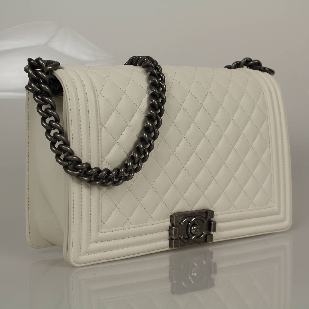 Medium Boy in a exquisite white calfskin with silver metal. The bag is of quilted leather trimmed in smooth leather with smooth leather sides and bottom; it has a full front flap with Boy Chanel signature CC push lock closure and silver chain link