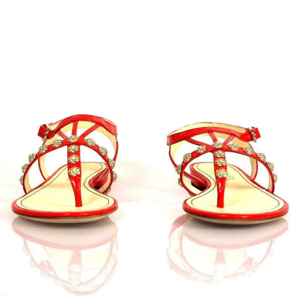 Chanel Orange patent leather sandals embellished with golden camellias through the top of the sandal.

Conditions: Brand new, but has worn soles because it was handled by customers

Includes: box and dust bags

DOES NOT INCLUDE TAGS

About