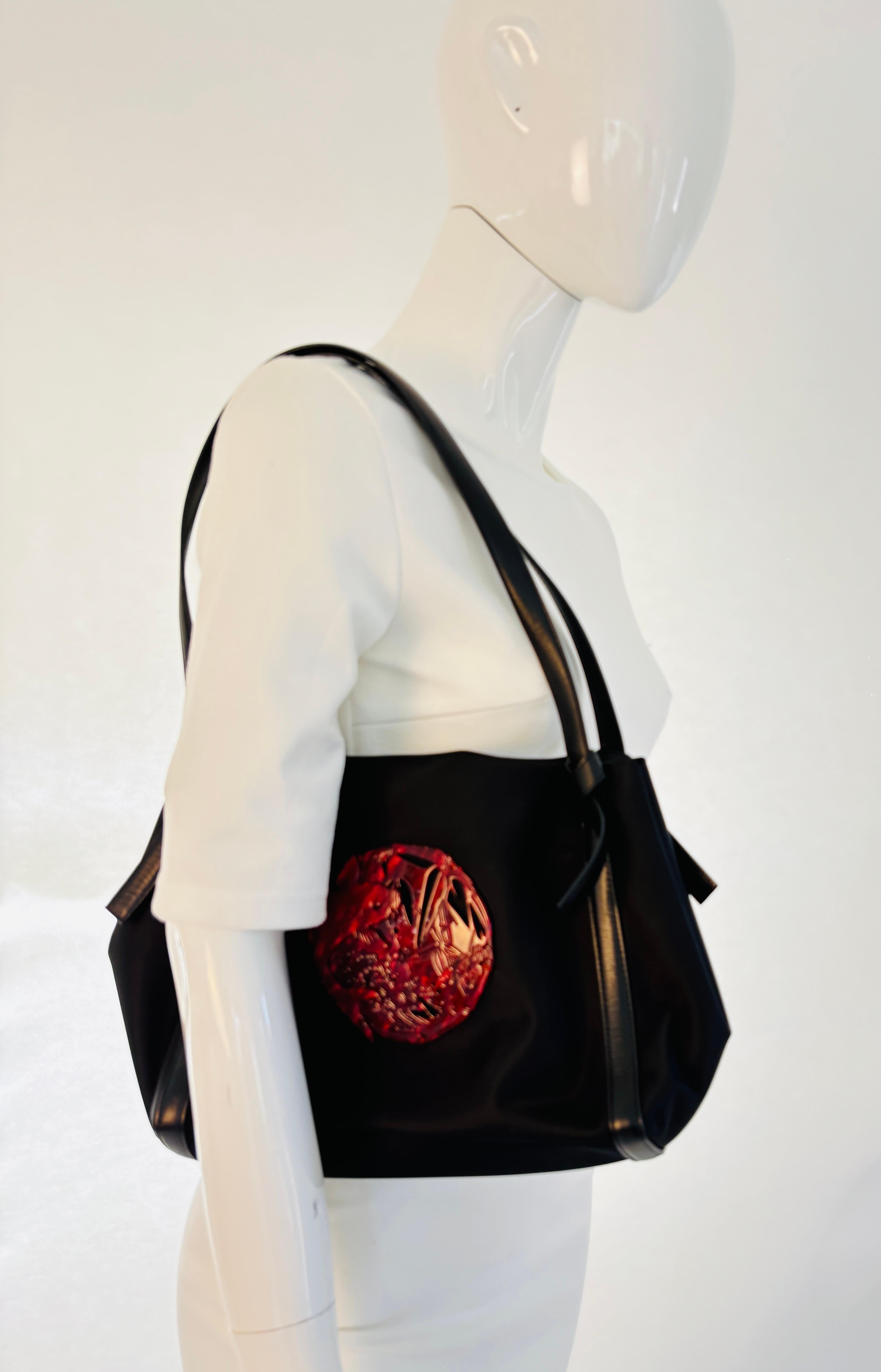Sac vintage Kenzo en nylon noir avec poisson Koi en résine.
Sac en nylon Kenzo des années 1990, avec bordures et poignées en cuir et décoré d'un grand poisson Koi Kamon en résine rouge.
Sac à bandoulière Kenzo des années 1990 avec Kamon en résine