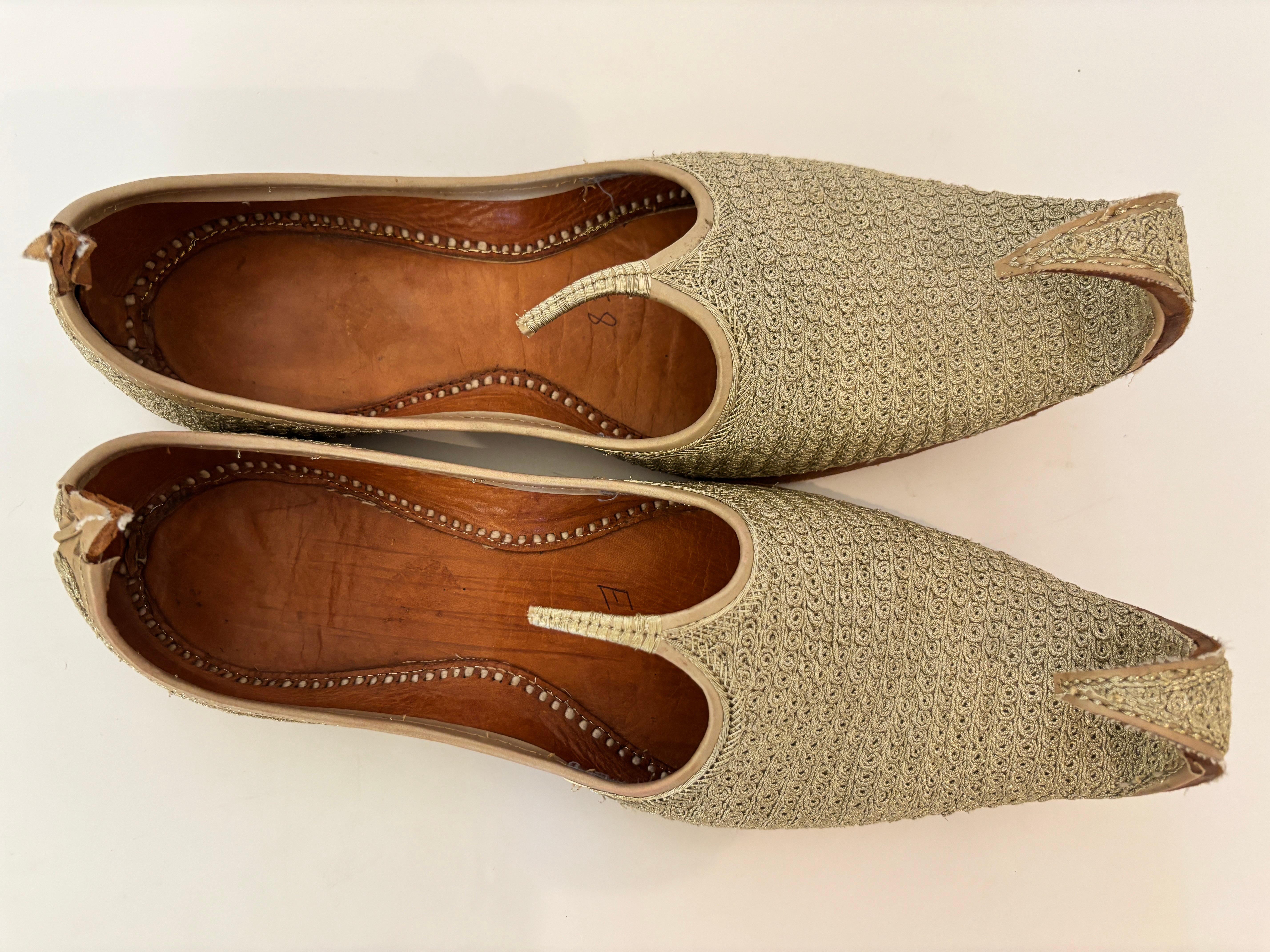 Exquise paire de chaussons en cuir indien brodés à la main à la fin du 20e siècle dans le style moghol
Une magnifique paire de pantoufles en cuir cousues et usinées à la main, somptueusement ornées de fils métalliques dorés dans des motifs complexes