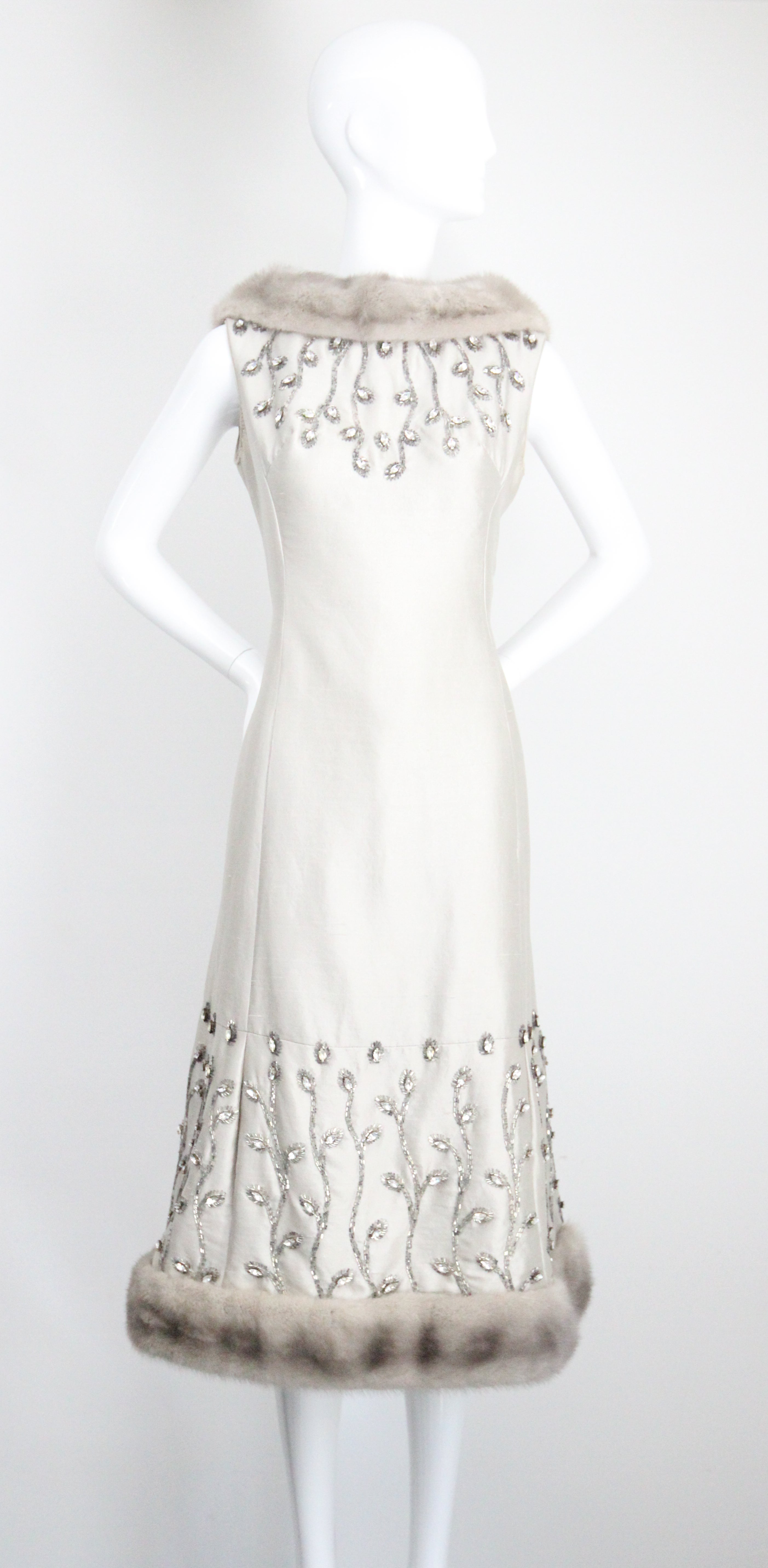 Realizzato nella più lussuosa seta shantung argentata e impreziosito da strass argentati incastonati e perline di vetro argentate a forma di foglia, rifinito con accenti di visone grigio, questo spettacolare abito da cocktail Lilllie Rubin degli