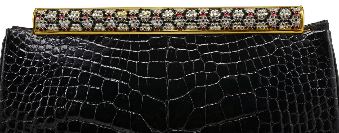 Magnificent vintage Judith Leiber black alligator evening bag with jeweled frame.  Frame is yellow gold tone with clear Swarovski crystals and cabochon garnets. Please note there are a few missing a Swarovski crystals, easily replaced, from backside