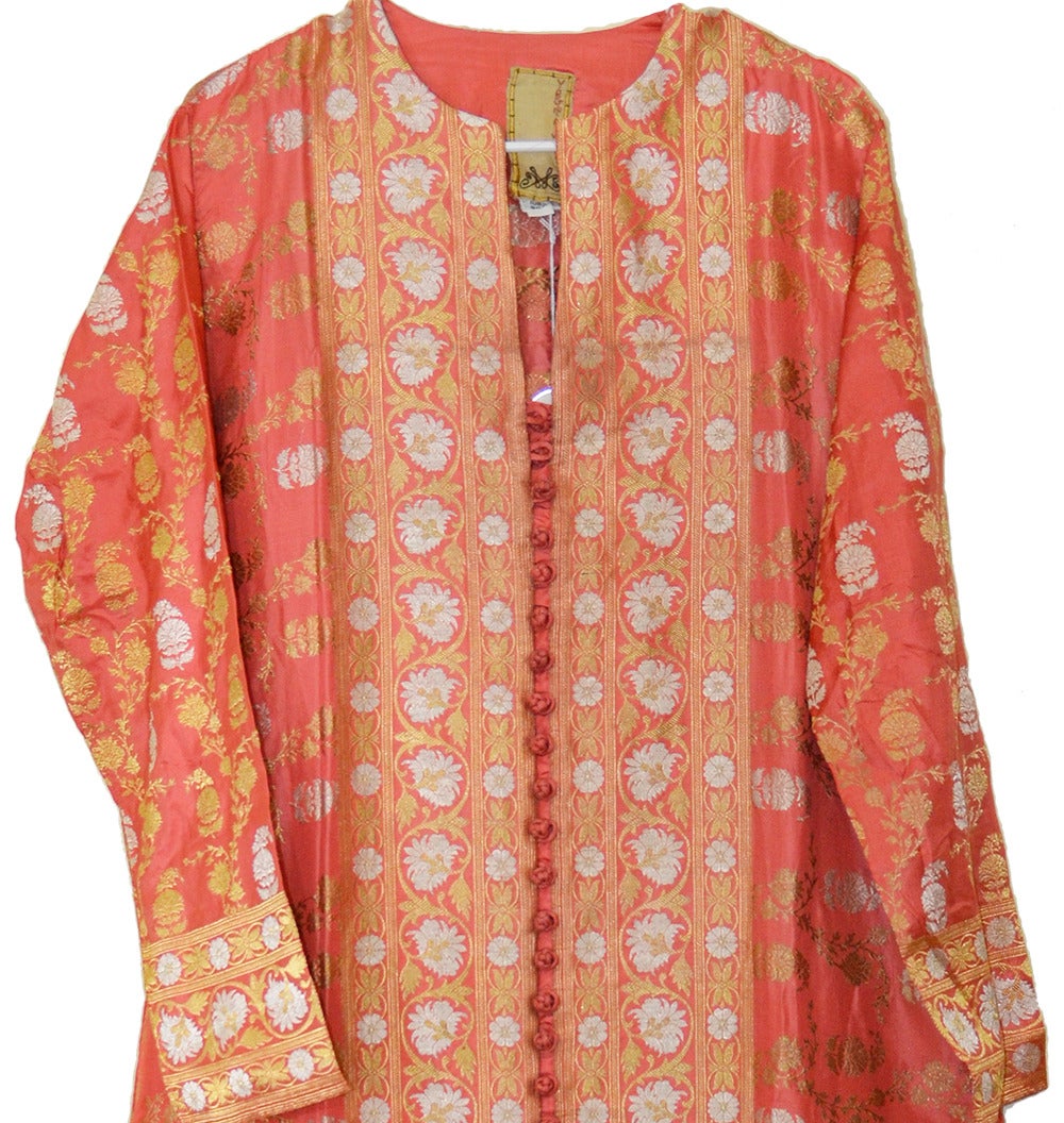 Magnificent Virginia Witbeck unconstructed coral silk caftan. Front opening robe with 25 handmade silk knotted buttons and hand turned stitched edges. Actual 24 gold thread throughout. Original retail in the early 2000s was $1250 at Bergdorf. In
