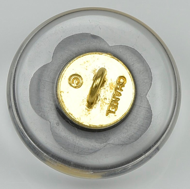 Cool and Classic, resin Chanel buttons...clear with Camillia center. New, mint condition. 6 pcs, size of a nickel.