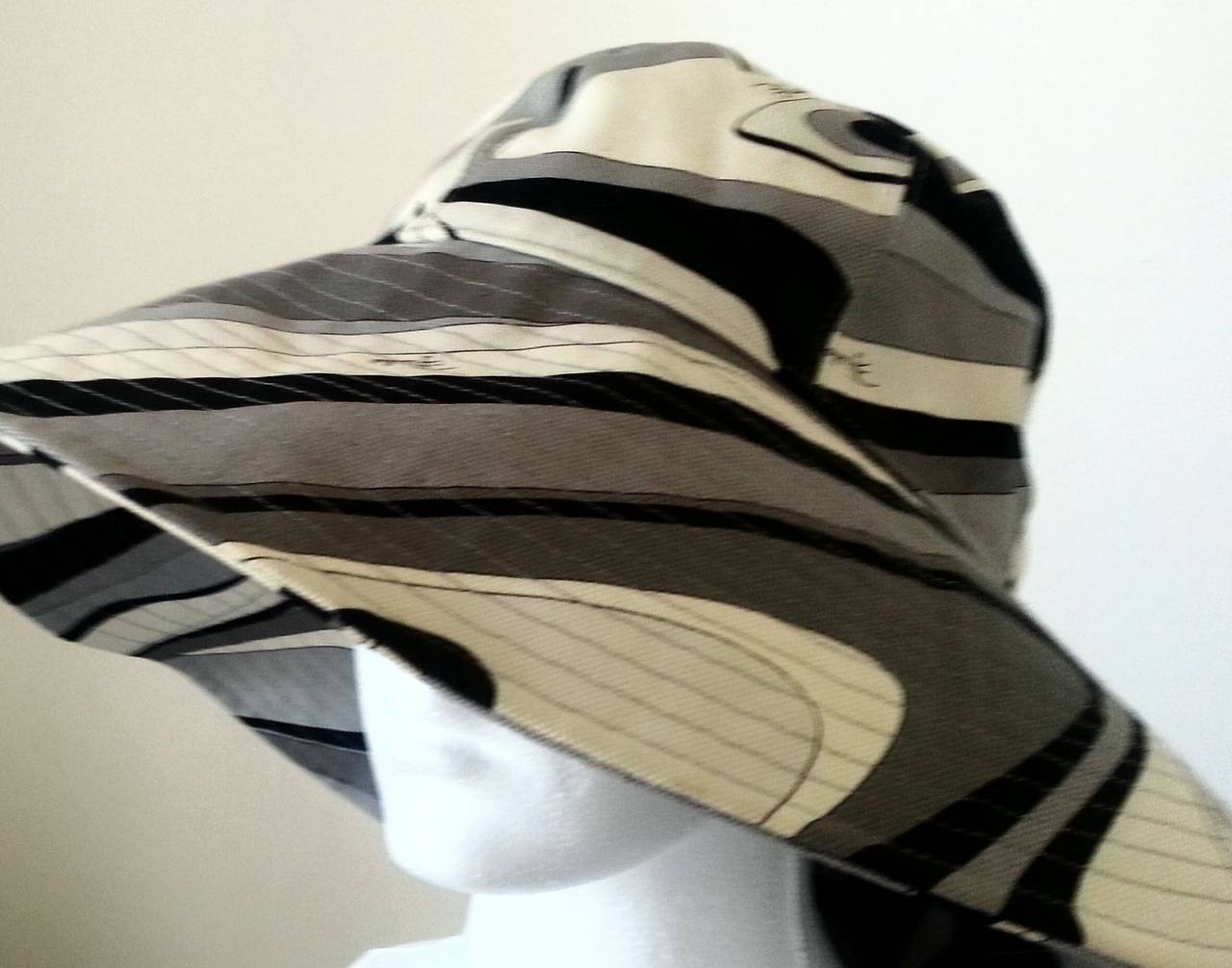 Emilio Pucci wide brim hat from the late 60s or early 70s. 

The print is classic Pucci, in monochrome black, white and grey. A very chic hat that can be worn as a sun hat or something altogether dressier with a smart blouse and trousers or a