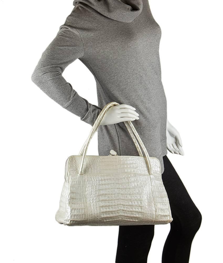 This Nancy Gonzalez Linda tote comes in lovely white crocodile leather. The interior features two additional compartments and is made of a beautiful and complementary lavender suede. There are two top zippered compartments for convenient