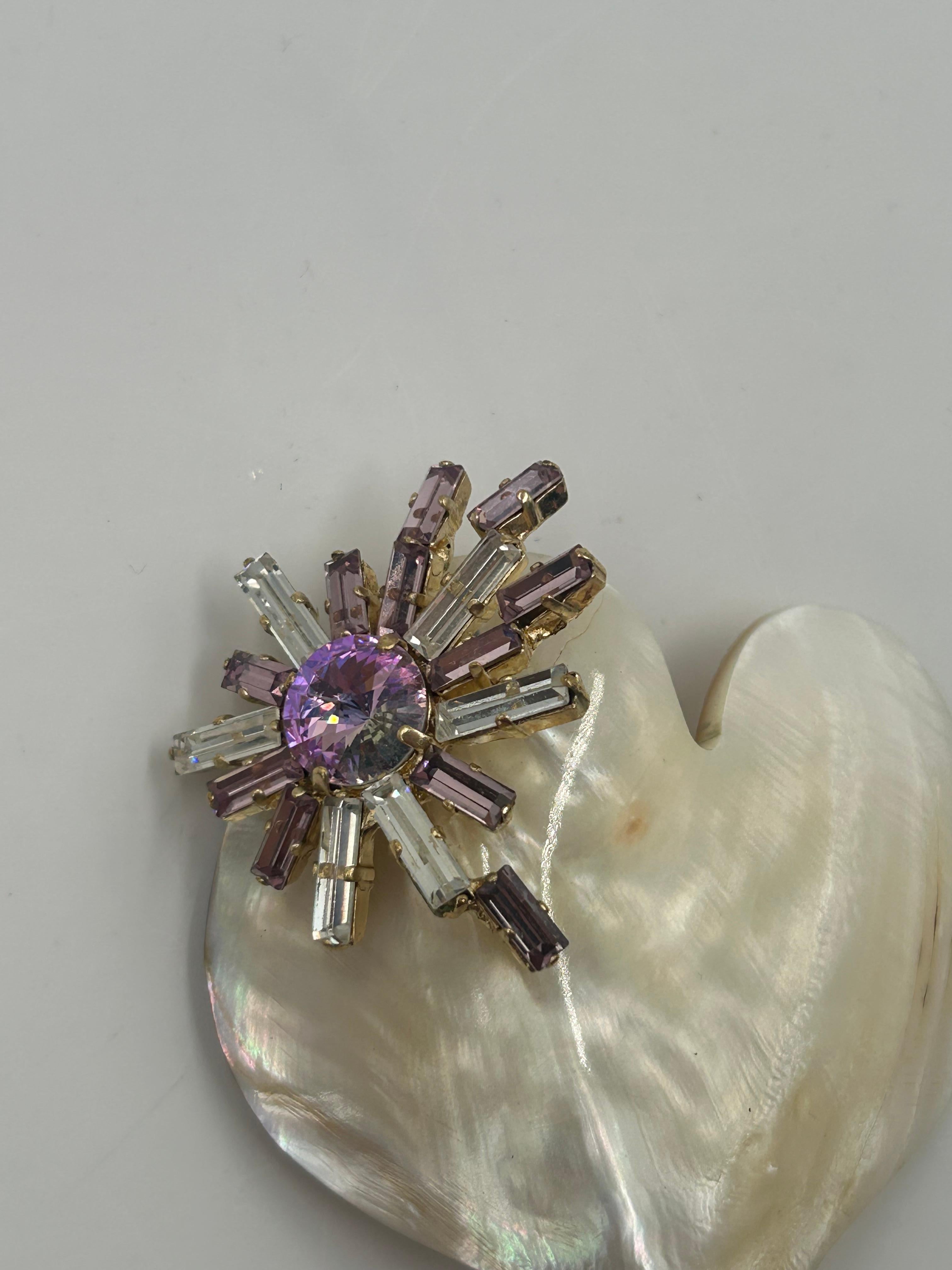 Spilla e ciondolo in madreperla Christian Lacroix. Eleganza e distinzione: questa spilla e ciondolo di Christian Lacroix presenta un centro luminoso in madreperla incastonato in una cornice scultorea in tonalità oro. Incarnando il caratteristico