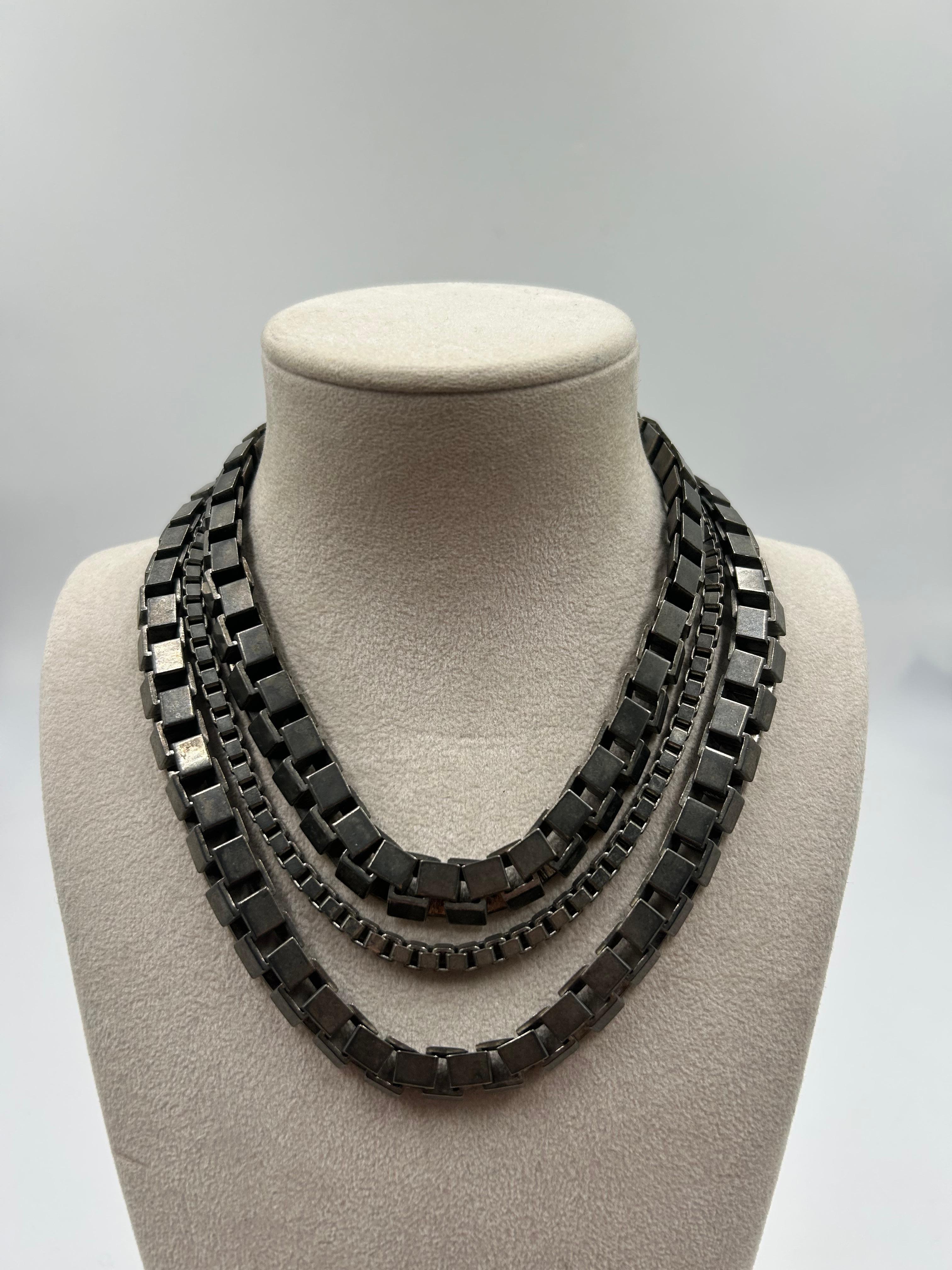 Frappant et sculptural, ce collier vintage Thierry Mugler présente un design audacieux en argent avec une silhouette futuriste et angulaire, signature de l'esthétique avant-gardiste de Mugler. Véritable pièce d'apparat des années 1980, elle se pose