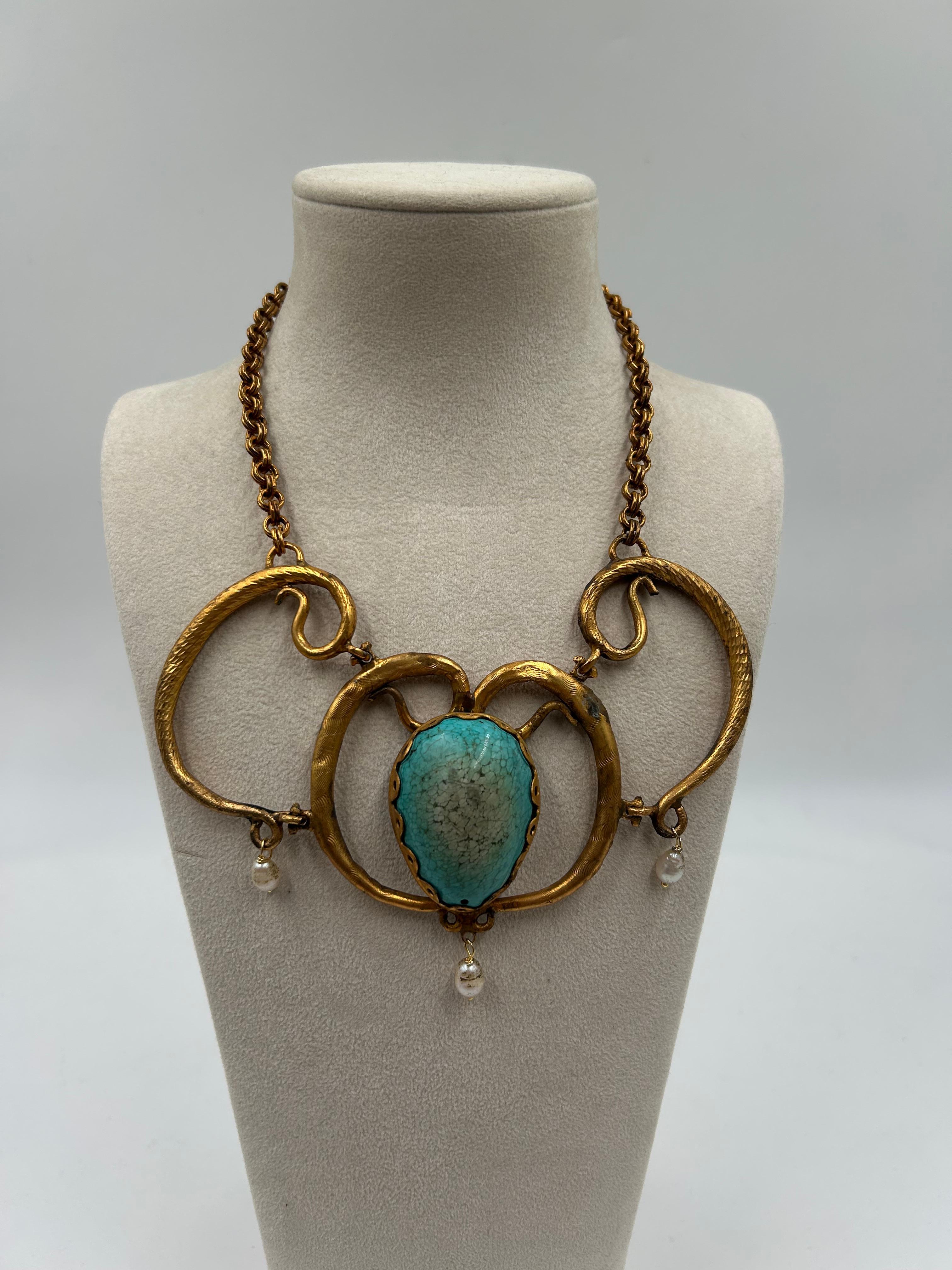 Atrevido y llamativo, este collar de latón presenta un diseño escultural con un rico acabado dorado que añade calidez y sofisticación. Perfecto para elevar cualquier atuendo, ofrece un toque moderno y artístico y se asienta cómodamente en el cuello