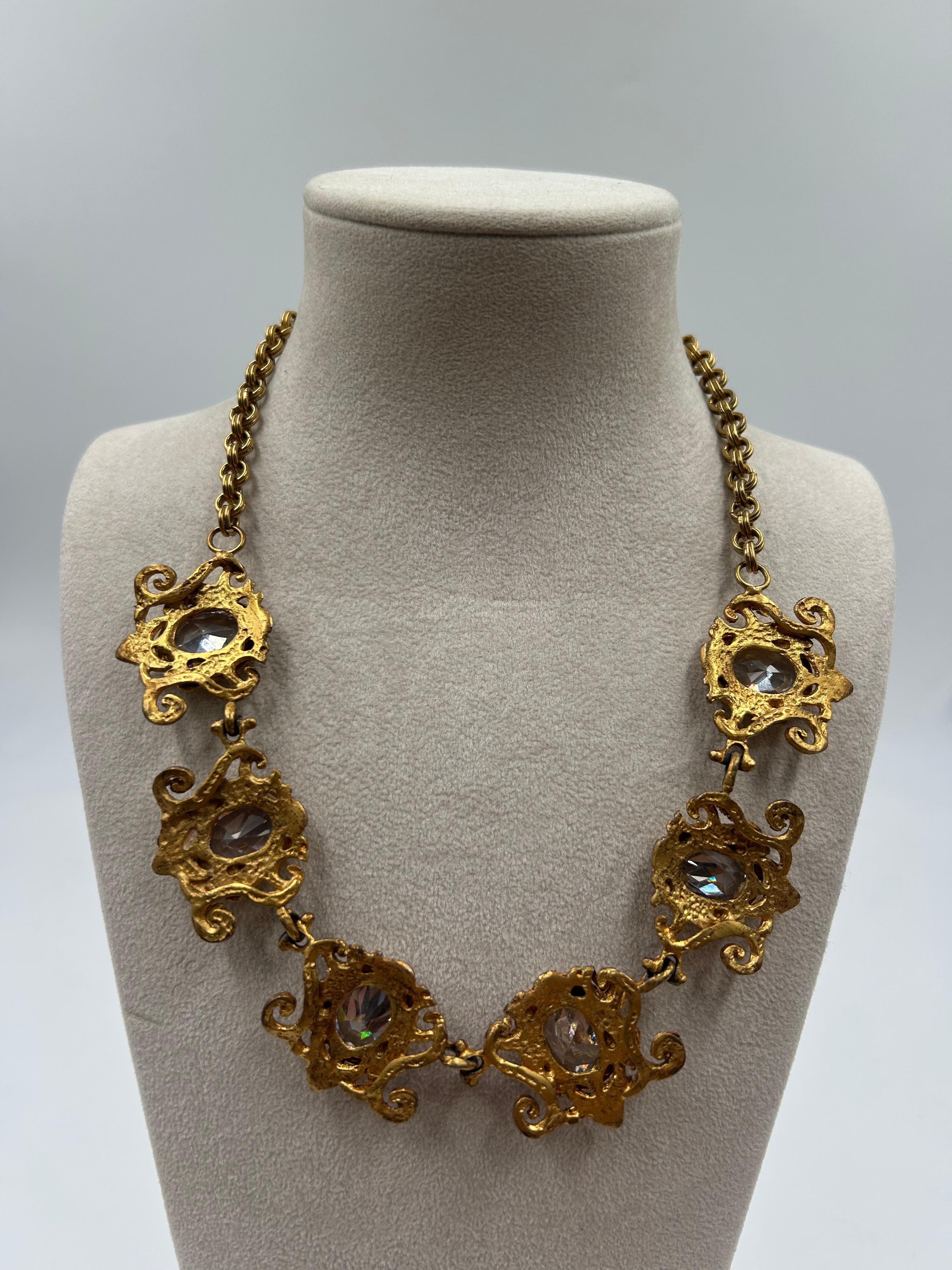 Radieux et raffiné, ce collier d'affirmation en laiton doré vintage présente un design élégant orné de cristaux étincelants qui captent magnifiquement la lumière. La riche finition dorée complète l'éclat des pierres, créant une pièce glamour et