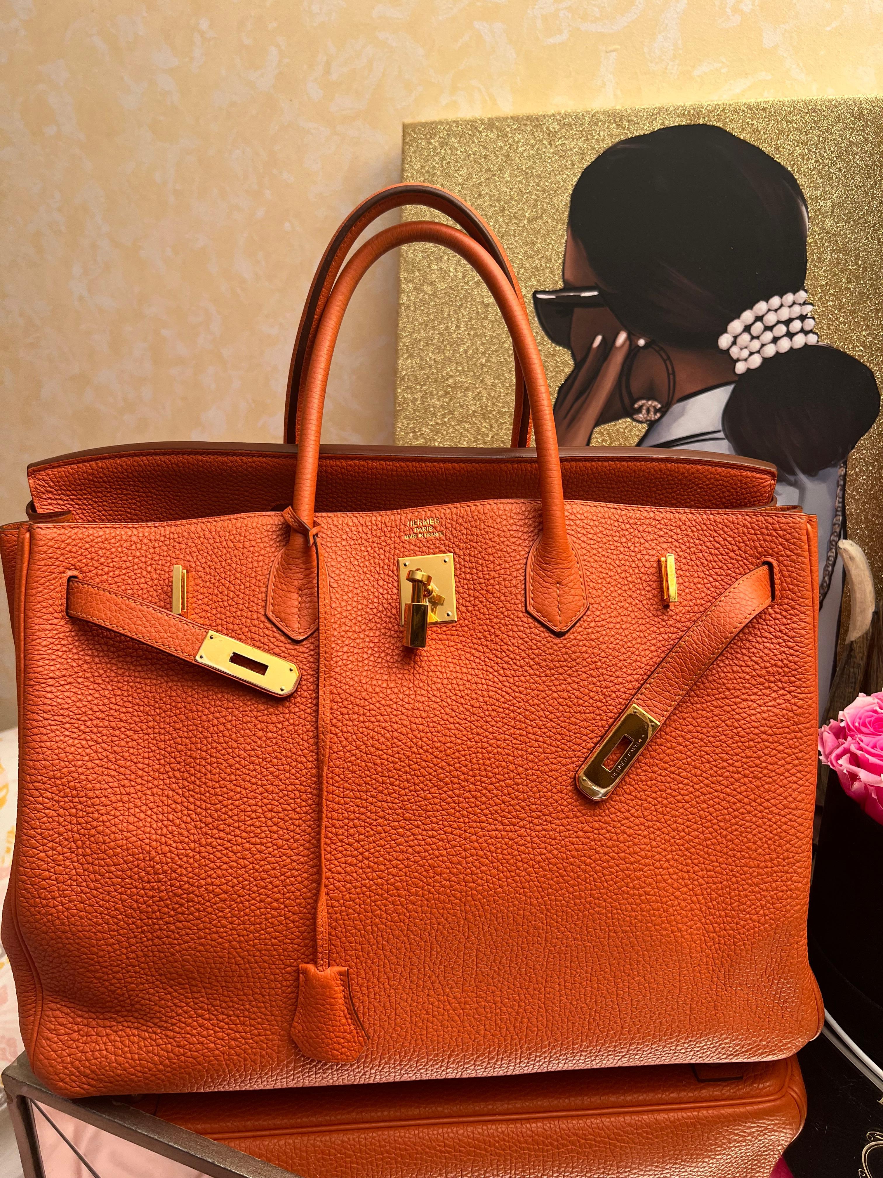 Hermès Birkin 40 Arancione Togo Hardware Oro usata. Questa Birkin è in pelle togo arancione con finiture dorate e presenta cuciture tonali, patta frontale, due cinturini con chiusura centrale ad alamari, clochette con lucchetto e due chiavi e doppi