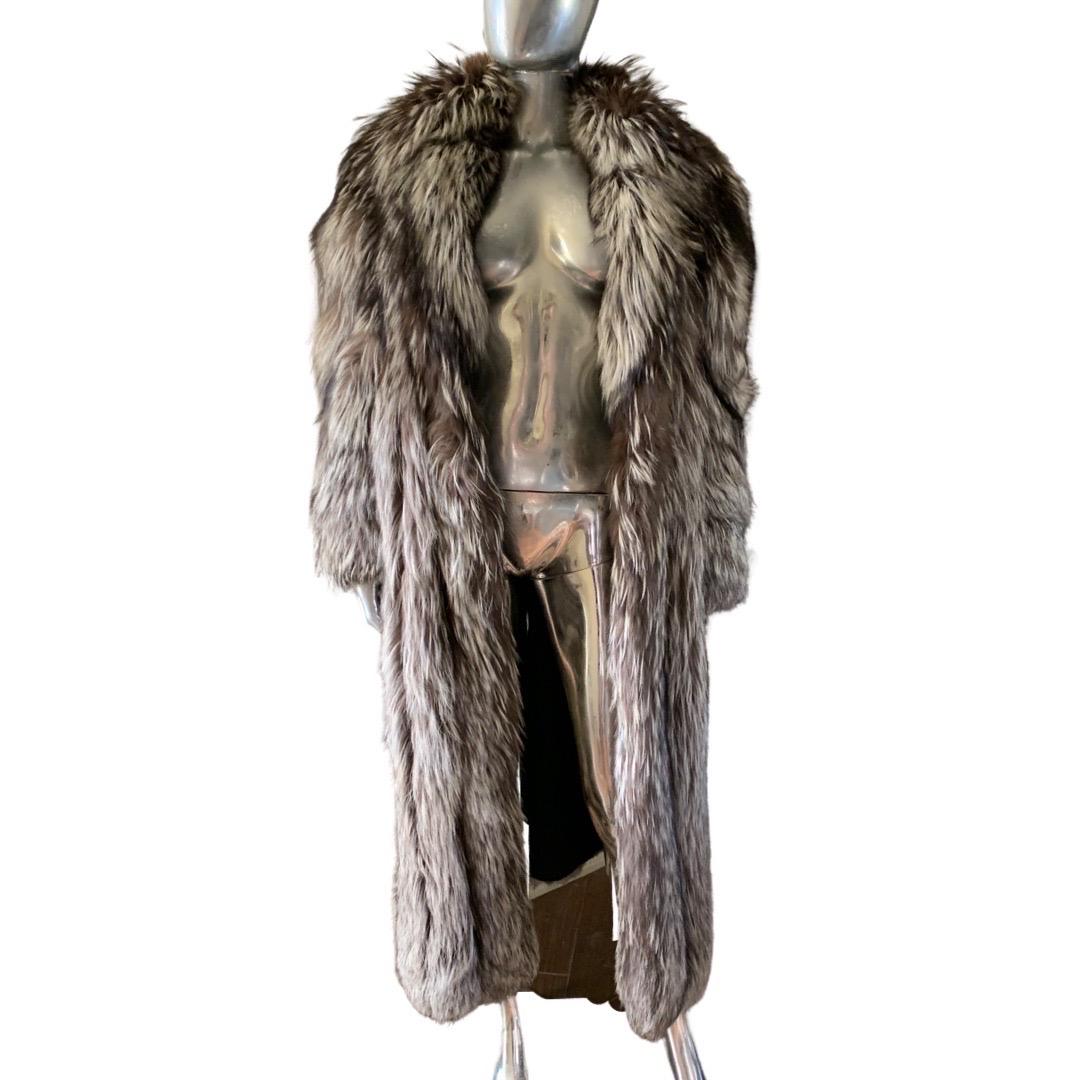 A very chic, high end coat from Canadian maker, Grosvenor. The coat is made of a very thick luxurious silver tipped fox fur. The coat has a hidden hook and eye at the waistline. Coat looks great open or closed. No size marked, it could be worn from