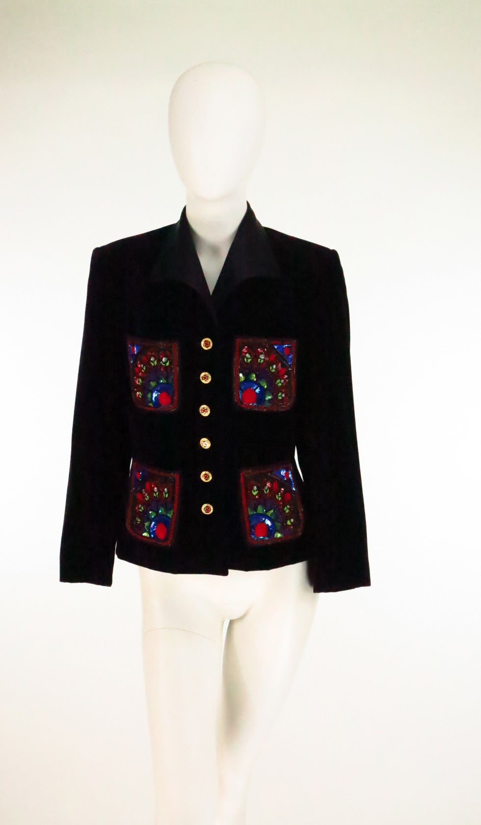 Escada Couture jewel embroidered velvet evening jacket from the 1990s...Single breasted black velvet jacket has 4 patch pockets each heavily decorated in jewel tone beads and sequins...Wing collar in black satin...Enamel and rhinesstone buttons