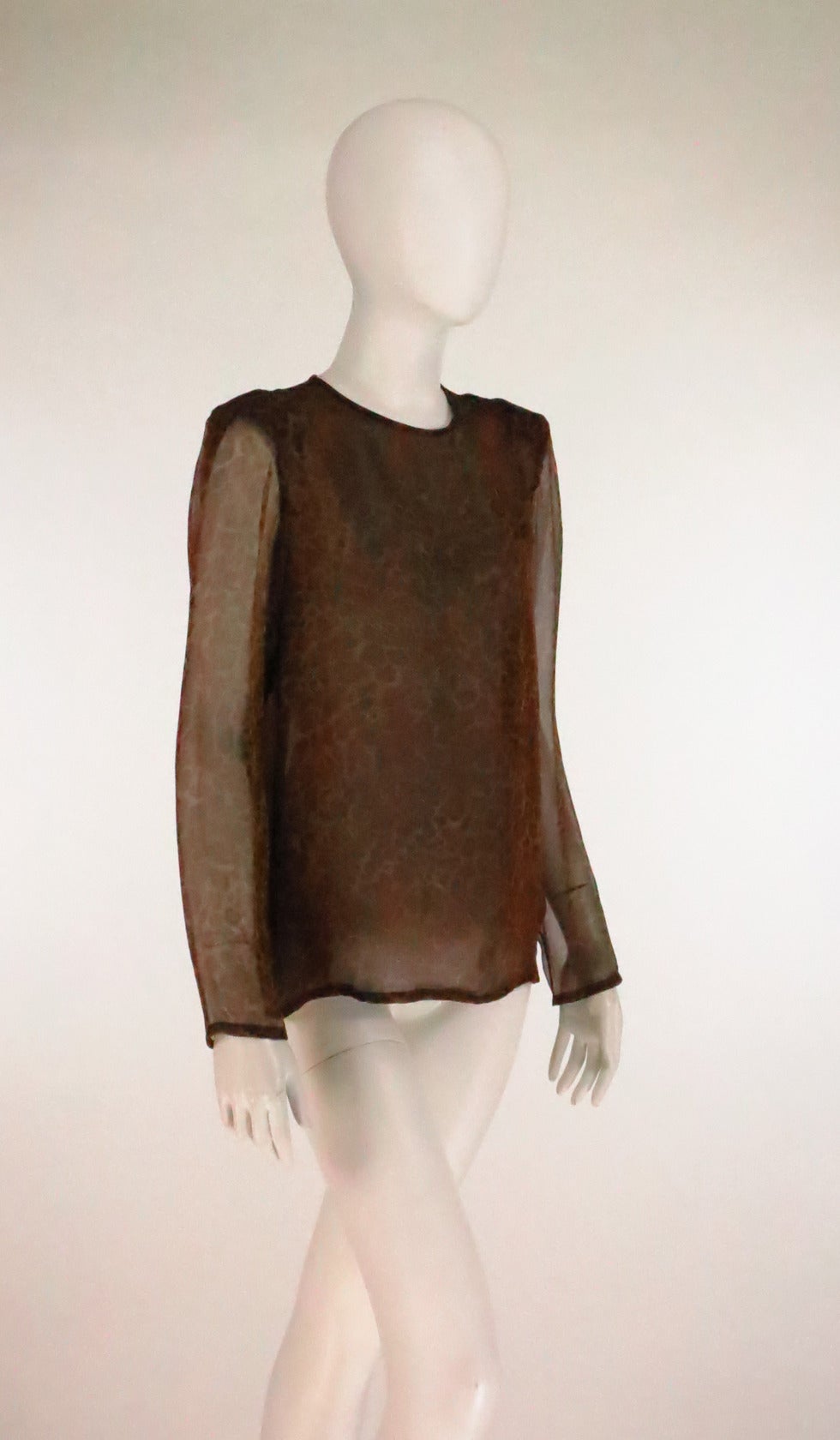 1990s Yves St Laurent leopard print silk chiffon blouse...Jewel neckline blouse has unlined long sheer sleeves with a hemmed cuff...The body of the blouse is lined in silk, pull on style with a single button and loop back neck closure..Lightly