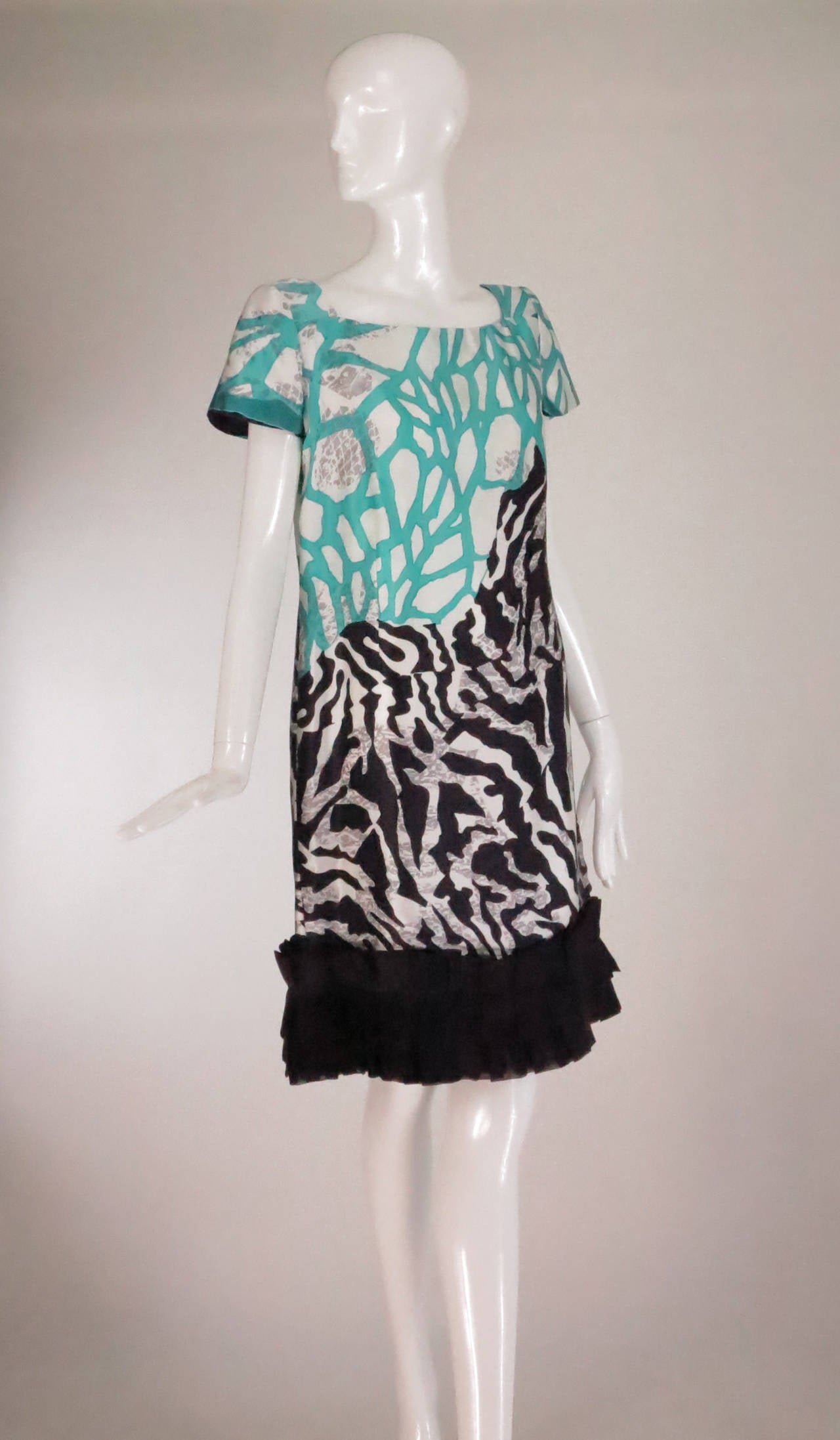 Palm Beach favourite designer, Paola Quadretti designs resort worthy dresses that are casually elegant and feminine...Hand made, short sleeve printed silk dress in turquoise, ivory white and black with splashes of gray...A line dress skims the body