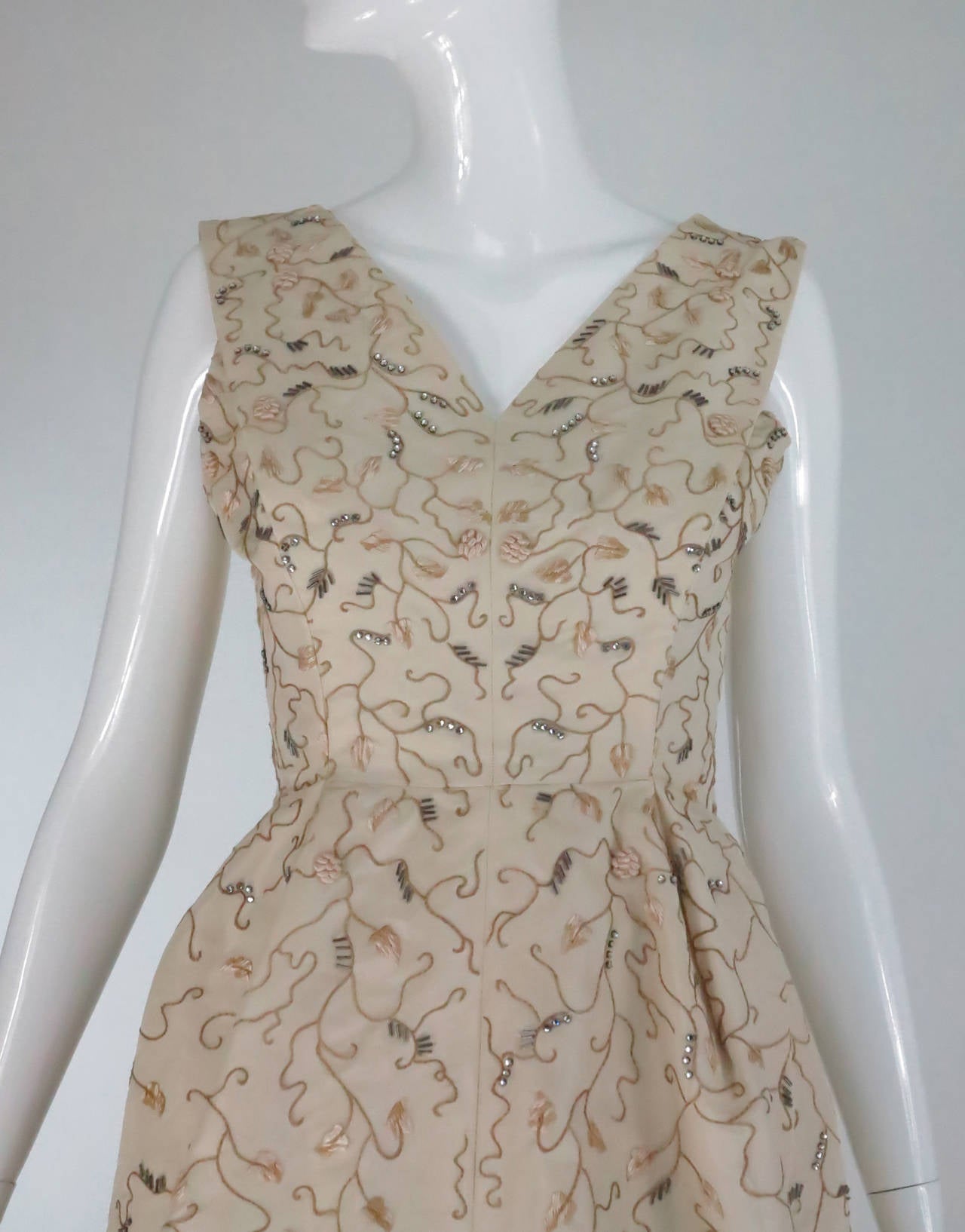 From the late 1950s a gorgeous Hattie Carnegie beaded & embroidered silk faille cocktail dress in ivory white...Foliate embroidery is done in gold silk thread with scattered three dimensional embroidered roundels, there are silver glass bugle beads