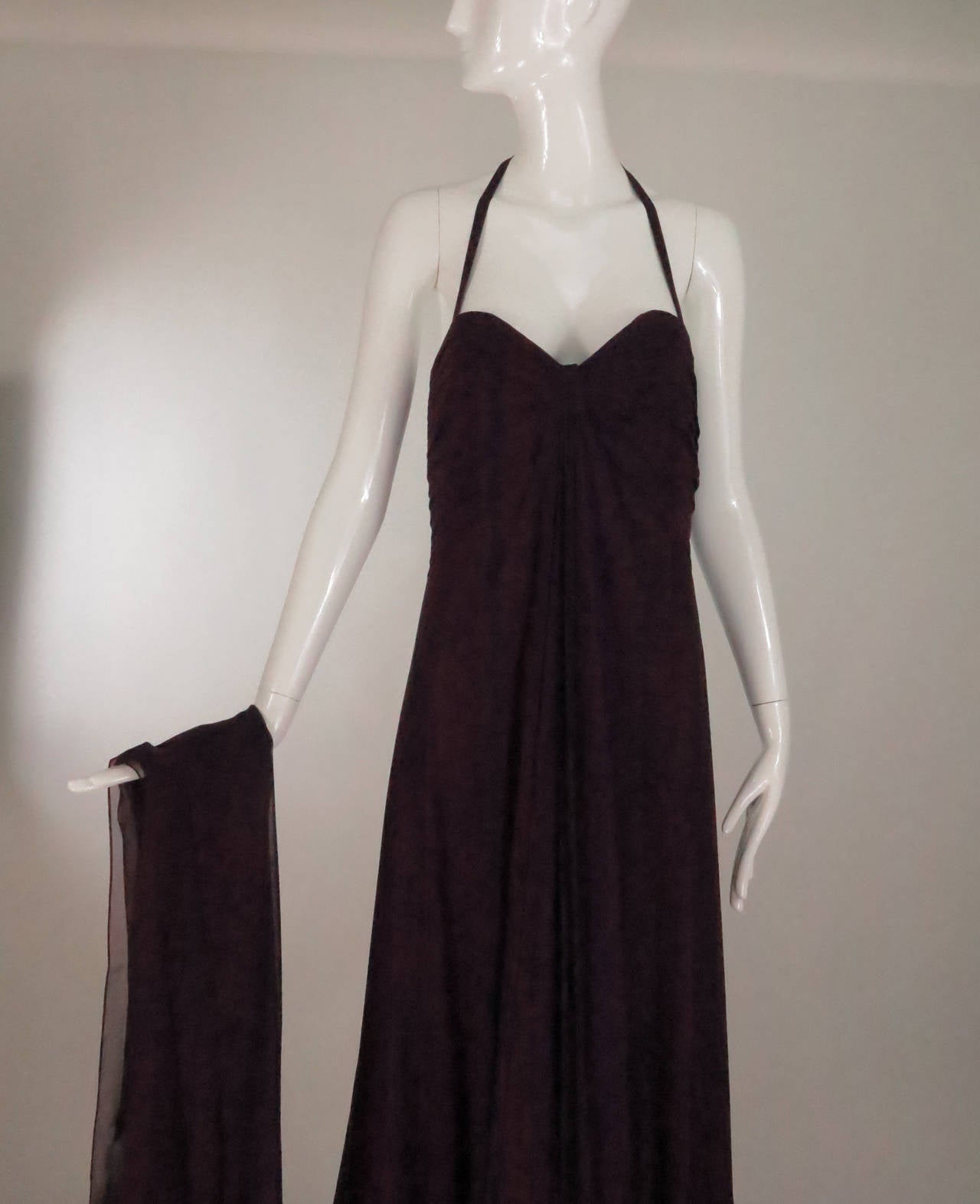 Goddess style gown in a shade of garnet silk chiffon…Unworn...Halter neck pleated draped bodice has a center vertical drape, the gown is bias cut and is flattering through the waist...The bodice is fully lined and lightly boned for shape…The dress