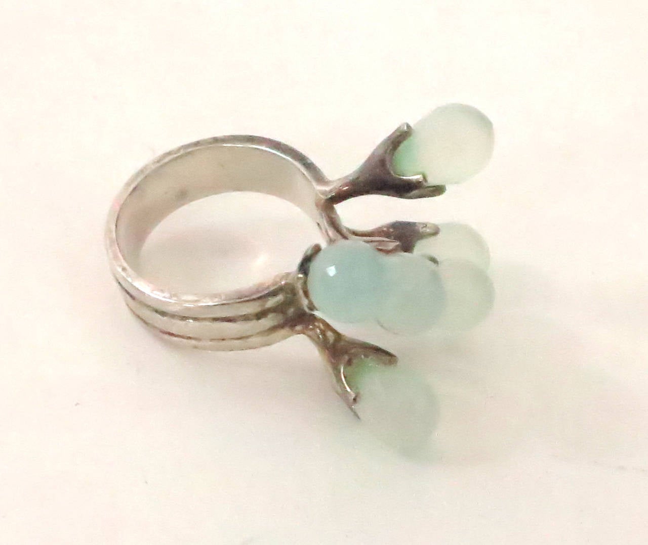 Unusual sterling silver ring set with faceted icy sea green stones, that float like Sputnik...Marked 925 (sterling silver). In excellent condition ready to wear.  Approx size 7 1/2