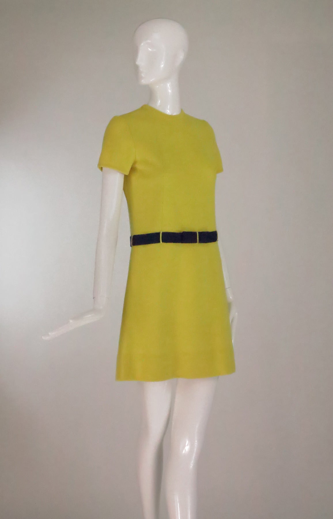Mod style lemon & purple double knit colour block mini dress from the early 1970s...A line dress has a jewel neckline and short sleeves...An attached purple knit waist band belt has a decorative bow at the front, self loops...The dress is unlined