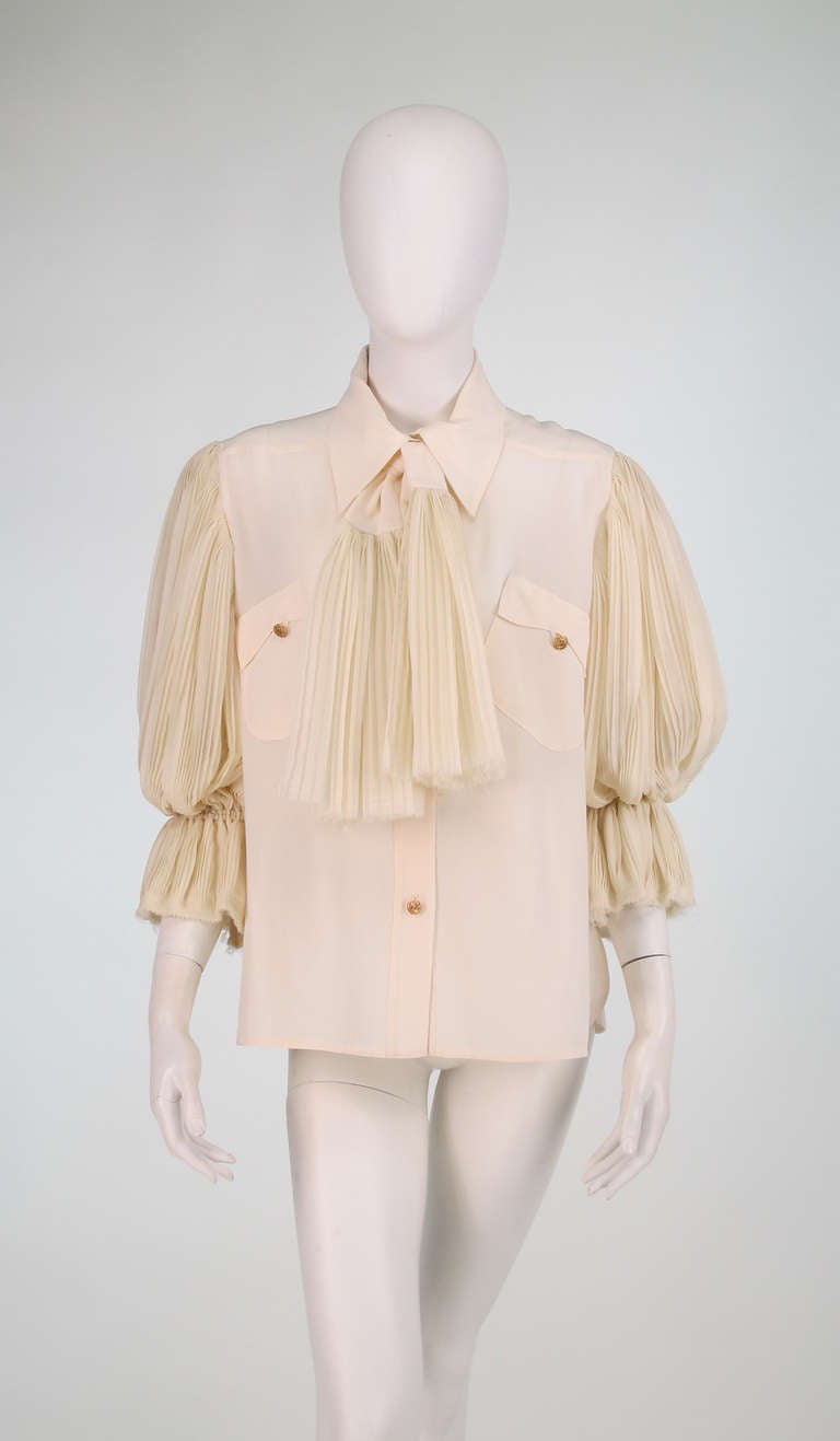 Fendi cream silk blouse...Classic style with a touch of romance...The gold button front blouse has angled chest pockets with gold button flaps...Stock tie has pleated chiffon ends that echo the romantic full pleated chiffon