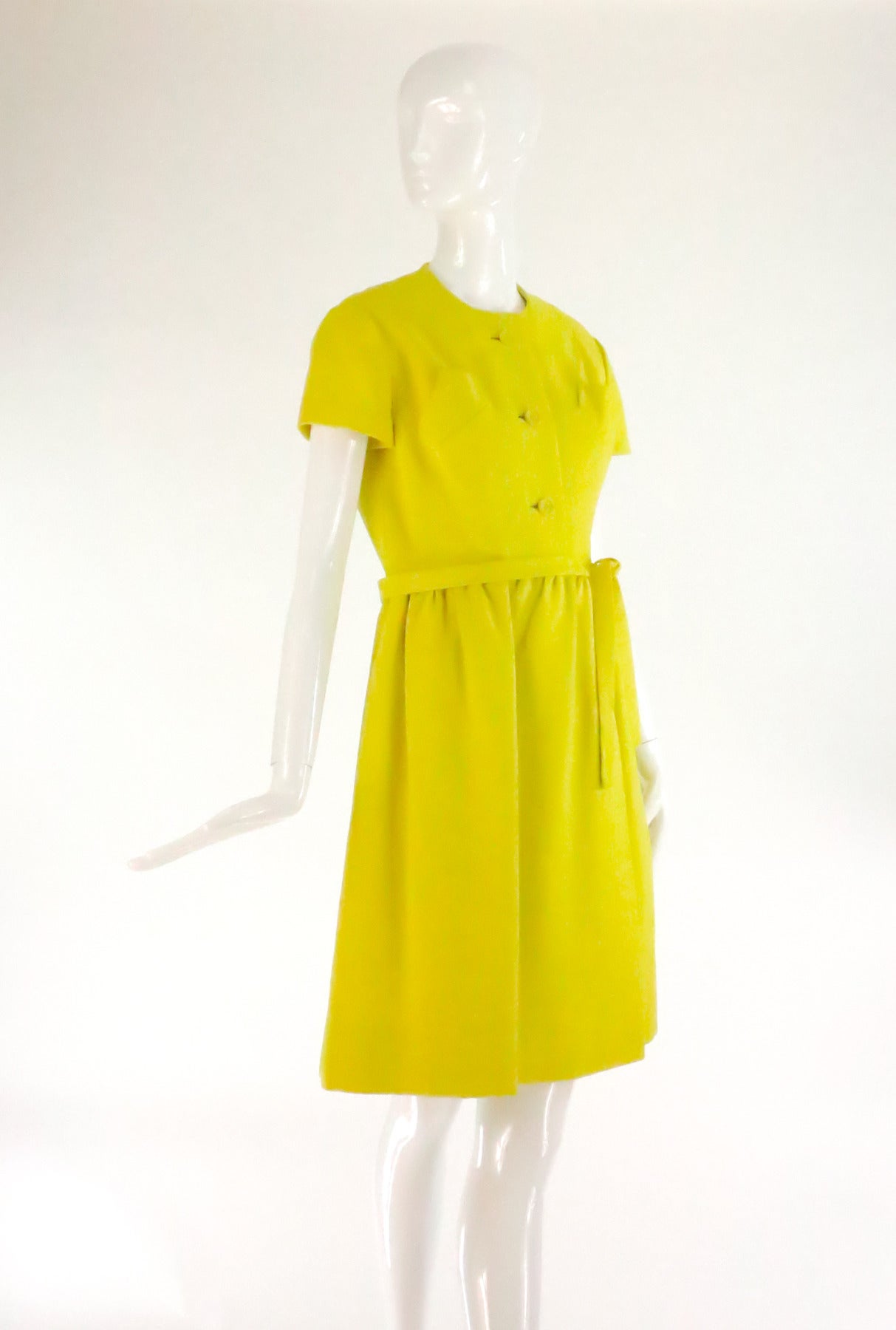 Lemon yellow linen dress from Geoffrey Beene, 1960s...Classic style as wearable today as it was in the 60s...Round neck, short sleeve dress closes at the front with decorative buttons, two shaped breast pockets...The skirt is softly gathered at the