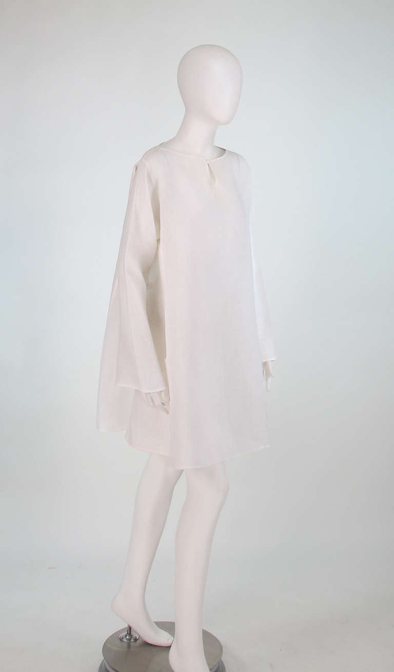 Krizia sheer white linen tunic...Pull on tunic with set in long full sleeves...Full A line shape...Large hip front open scoop pockets...Nice seaming detail...Single self button and loop at neck center front...Marked size 44 Italy...

In excellent