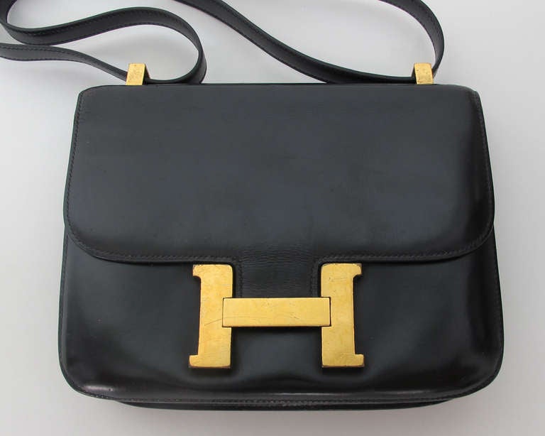 Hermes Constance bag black in box calf...From the 1970s...This bag has been to Hermes to have the shoulder strap replaced...It is in good condition with wear to the H clasp, and wear to the side seam where it attaches to the flap (see