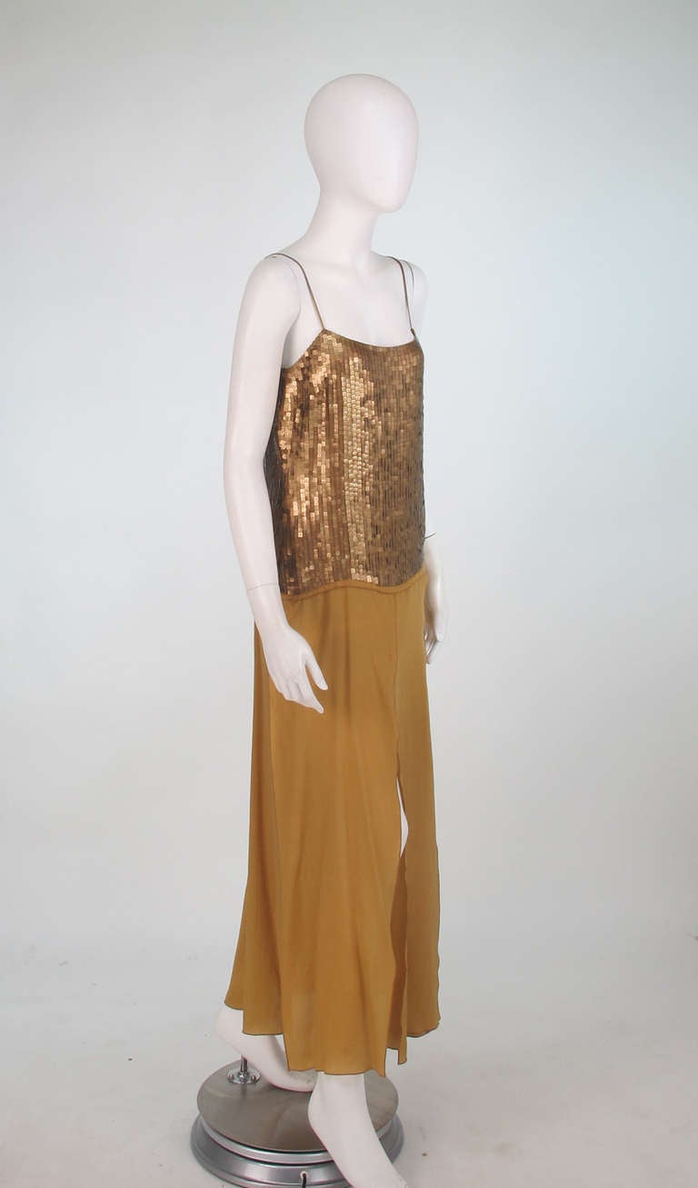 Sleek, 1970s Genny gold sequin & silk chiffon evening gown...The low cut bodice of this gown is covered in square bronze/gold sequins, with narrow soft  gold leather shoulder straps, the skirt is constructed of floating panels of bronze gold silk