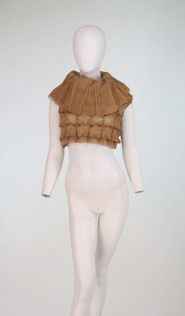 Issey Miyake gold silk cropped pucker top...Sleeveless, petal like turtleneck top made from smocked silk,similar to organza, creating a pucker texture...

In excellent wearable condition... All our clothing is dry cleaned and inspected for