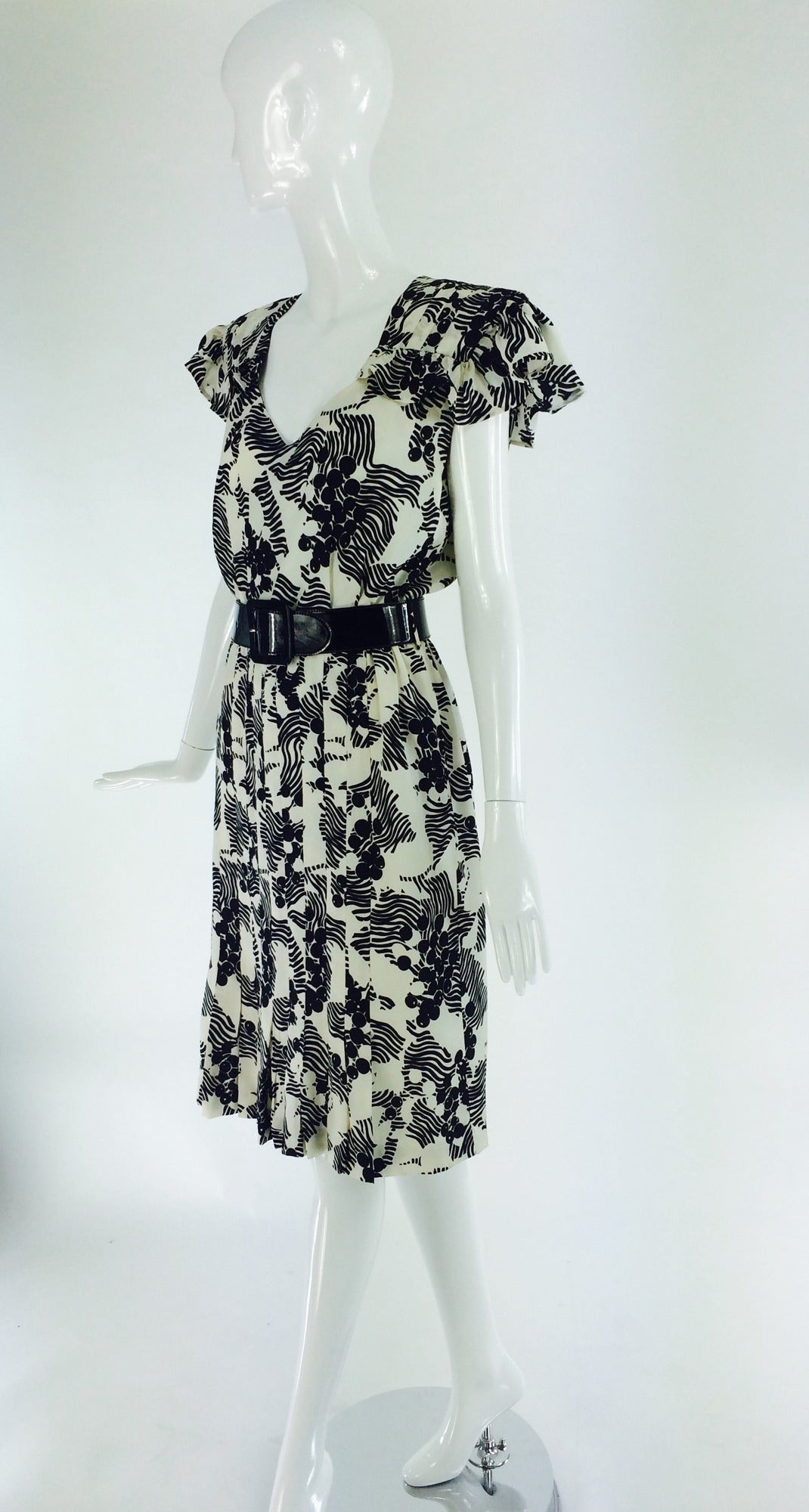 Andre Laug early 1990s black & white silk print dress...Deep V neckline, short ruffle pleated shoulder, shoulders are padded...The skirt has stitch down pleats at the front, side seam pockets and soft gathering at the waist back...The dress is fully