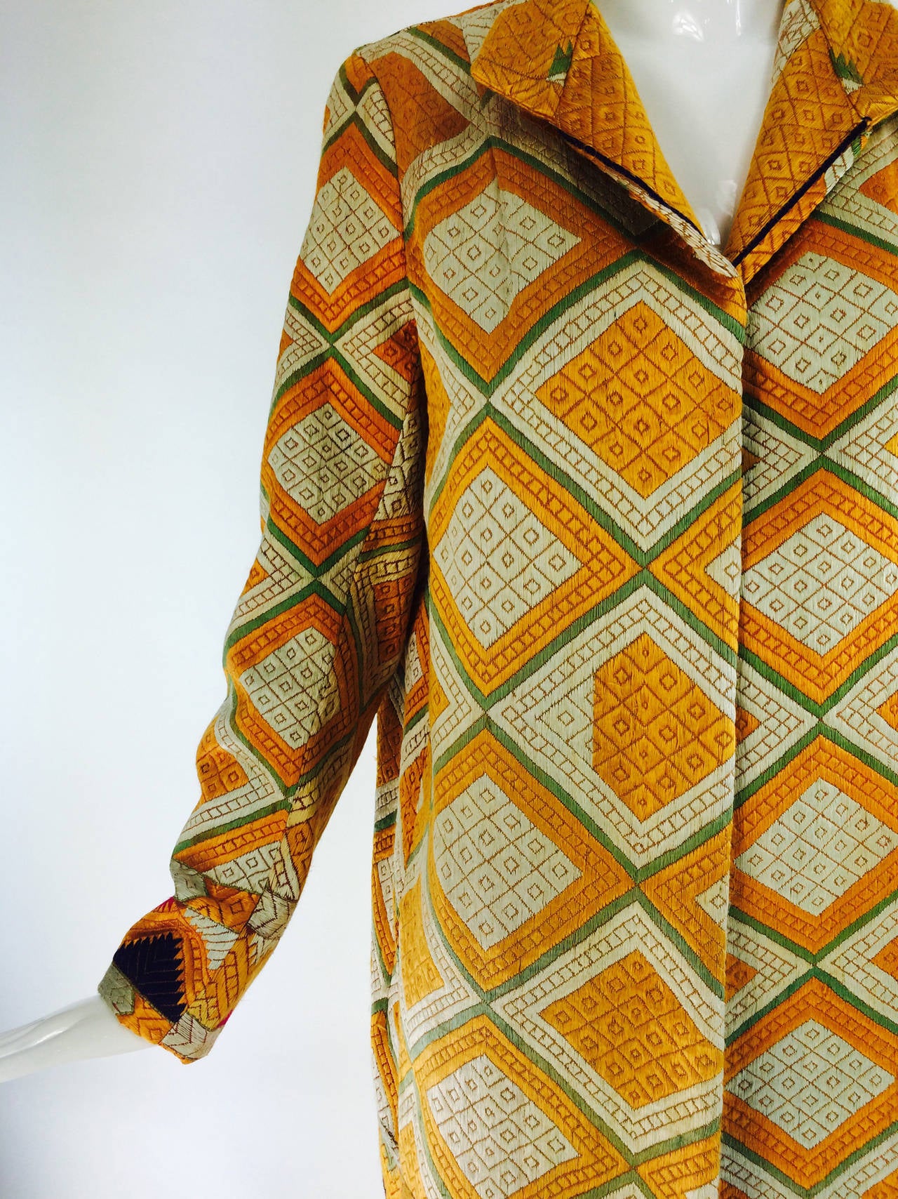 A beautiful coat from the 1920s made from a Punjabi chand bagh cotton embroidered textile...The fabric in this coat is completely hand embroidered (from the reverse side) in bright silk floss on handwoven cotton fabric most often in a reddish brown