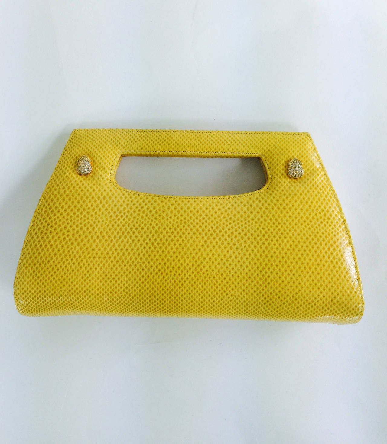 Judith Leiber bright yellow karung leather structured handle handbag...Perfect for evening & cocktails...The bag has a set in handle...Two Swarovski crystal appliques are set on either side of the handle at the front...The bag closes with hidden
